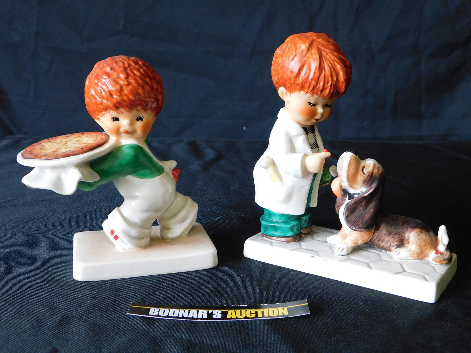 Lot of 2 Goebel Figurines: Lot of 2 Goebel Figurines including Say A-A-A-AAH and Nothing Beats a Pizza. You are bidding at a live sale, please read the terms and conditions. We are offering contact-less pick ups at our South Br