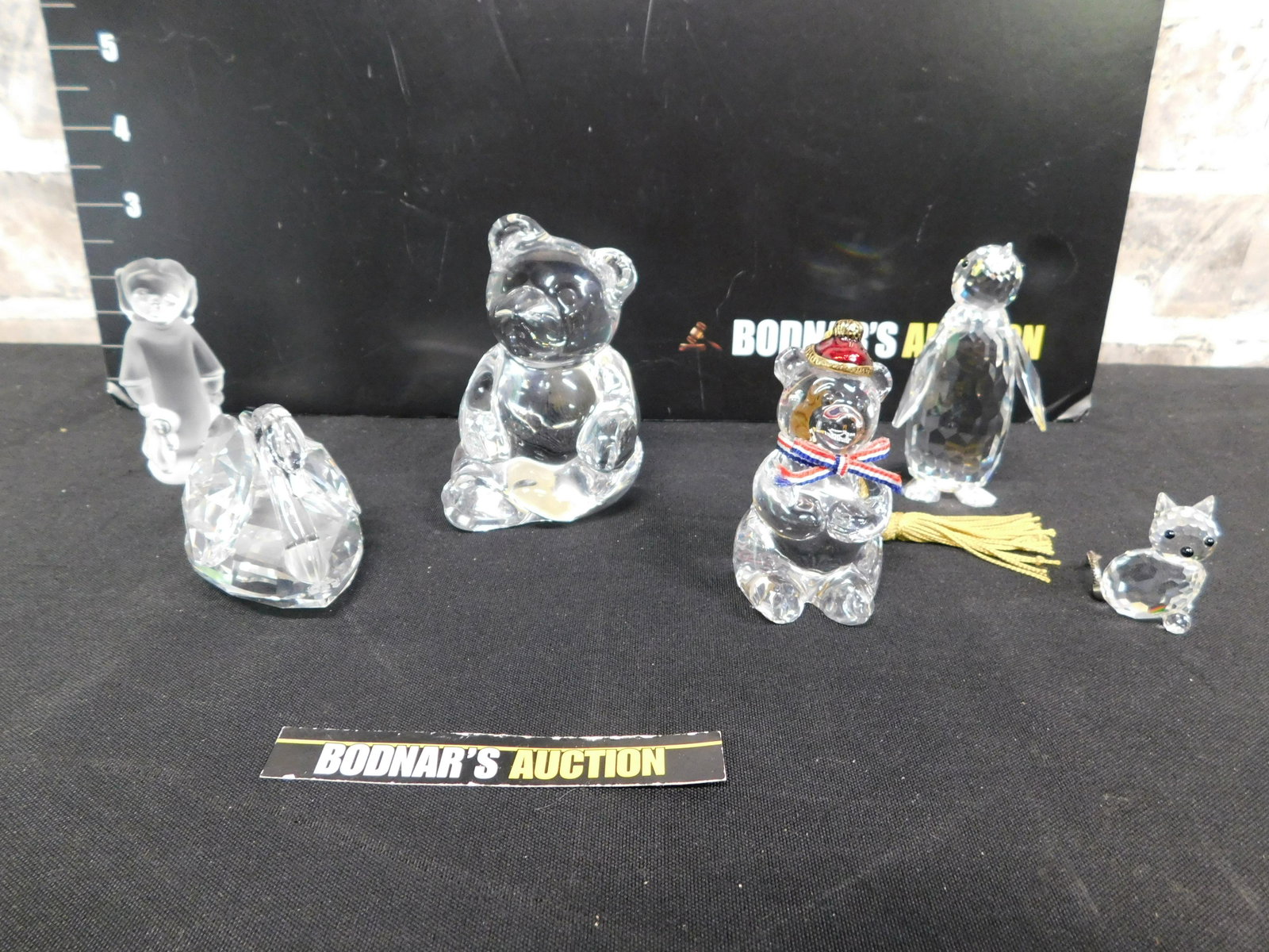 Lot of Crystal Figurines - Some As-Is: Lot of Crystal Figurines. Included is a Swarovski Penguin - Chip on Tail, Swarovski Cat - Chip on Ear, Swarovski Swan, 2 Made in Germany Bears, and a Frosted Girl Figurine. This sale is an in-house sh