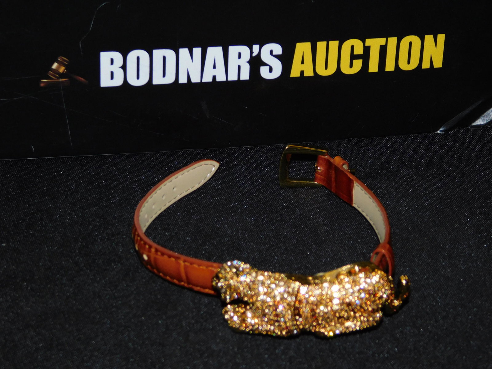 Adrianne Panther Watch: Adrianne panther watch done in crystal rhinestones throughout with a brown leather band and mother of pearl face. Measures approx. 8". All invoices must be paid within 24 hours of the sale. All items 