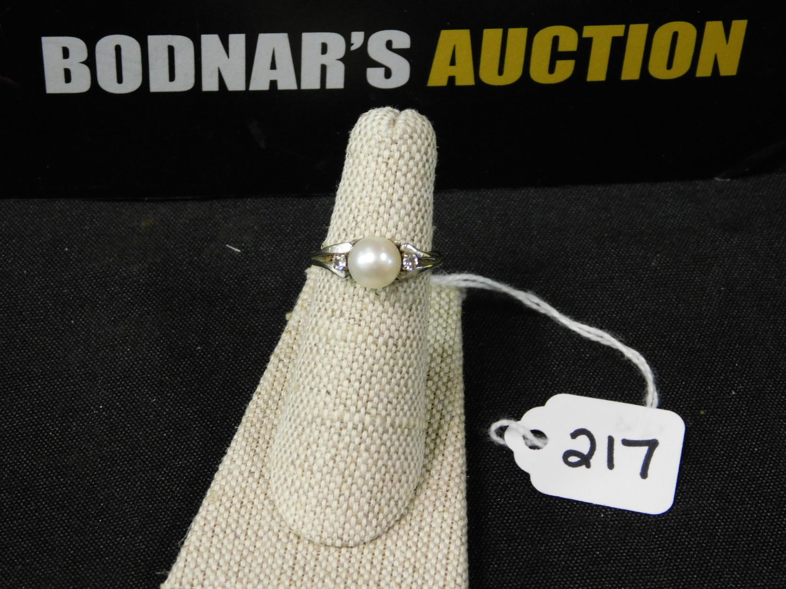 14K Pearl and Diamond Ring: 14K white gold women's ring with a pearl and 2 diamonds on either side. Marked. Size 5 1/2. All invoices must be paid within 24 hours of the sale. All items are shipped USPS and will be billed separat