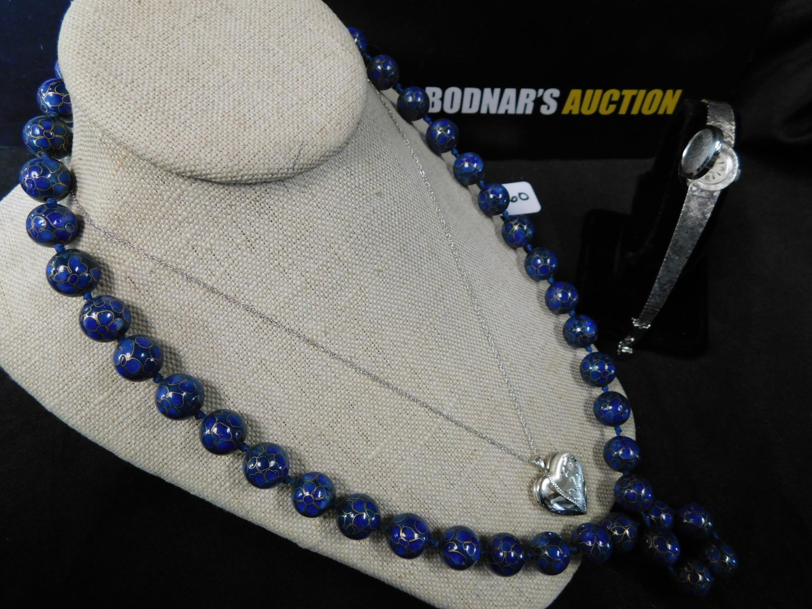 Lot of Jewelry: Lot of jewelry including a silver tone Sheffield watch, a blue heavy cloisonne necklace and a sterling silver necklace with locket. Necklace and pendant are marked. Sterling necklace measures approx. 