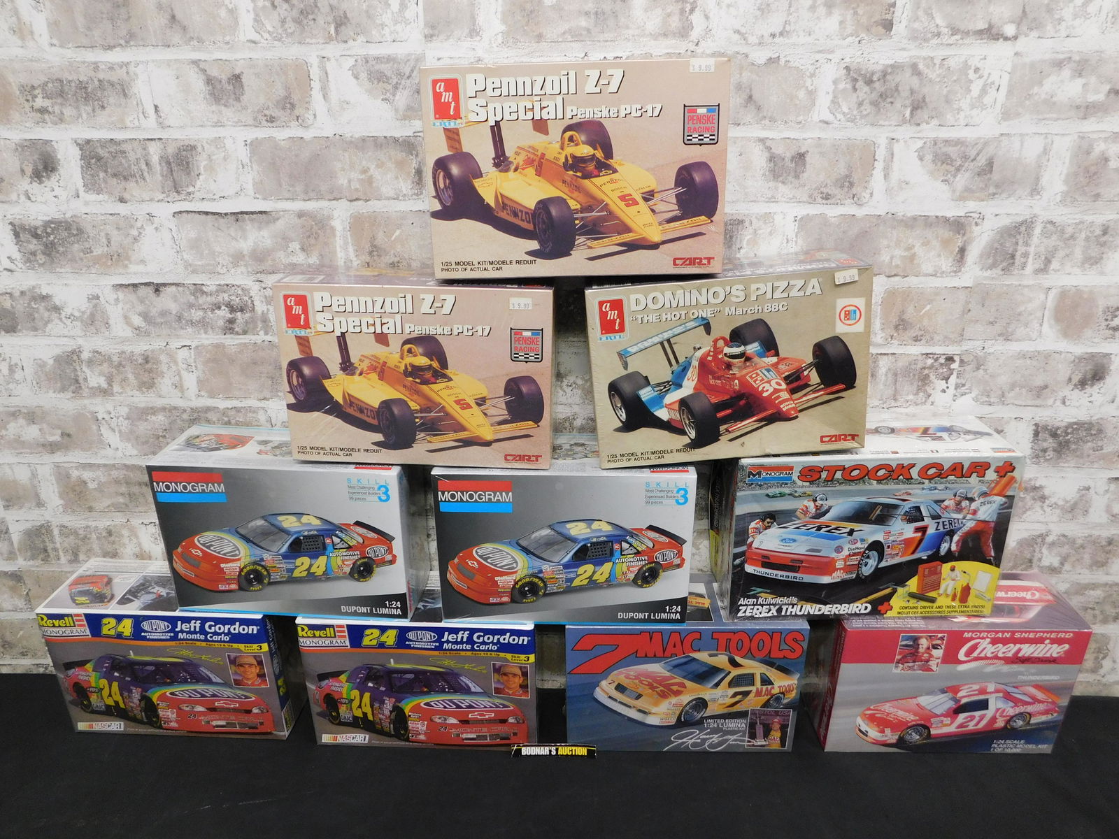 Lot of 10 Racing Model Kits - Mixed Brands: Lot of 10 Sealed and Unsealed 1:24 and 1:25 Scale Racing Model Kits. Only one is unsealed. Mixed Brands. The AMT Model Kits are 2x Pennzoil Z-7 Special PC-17 #5, and Domino's Pizza "The Hot One" March