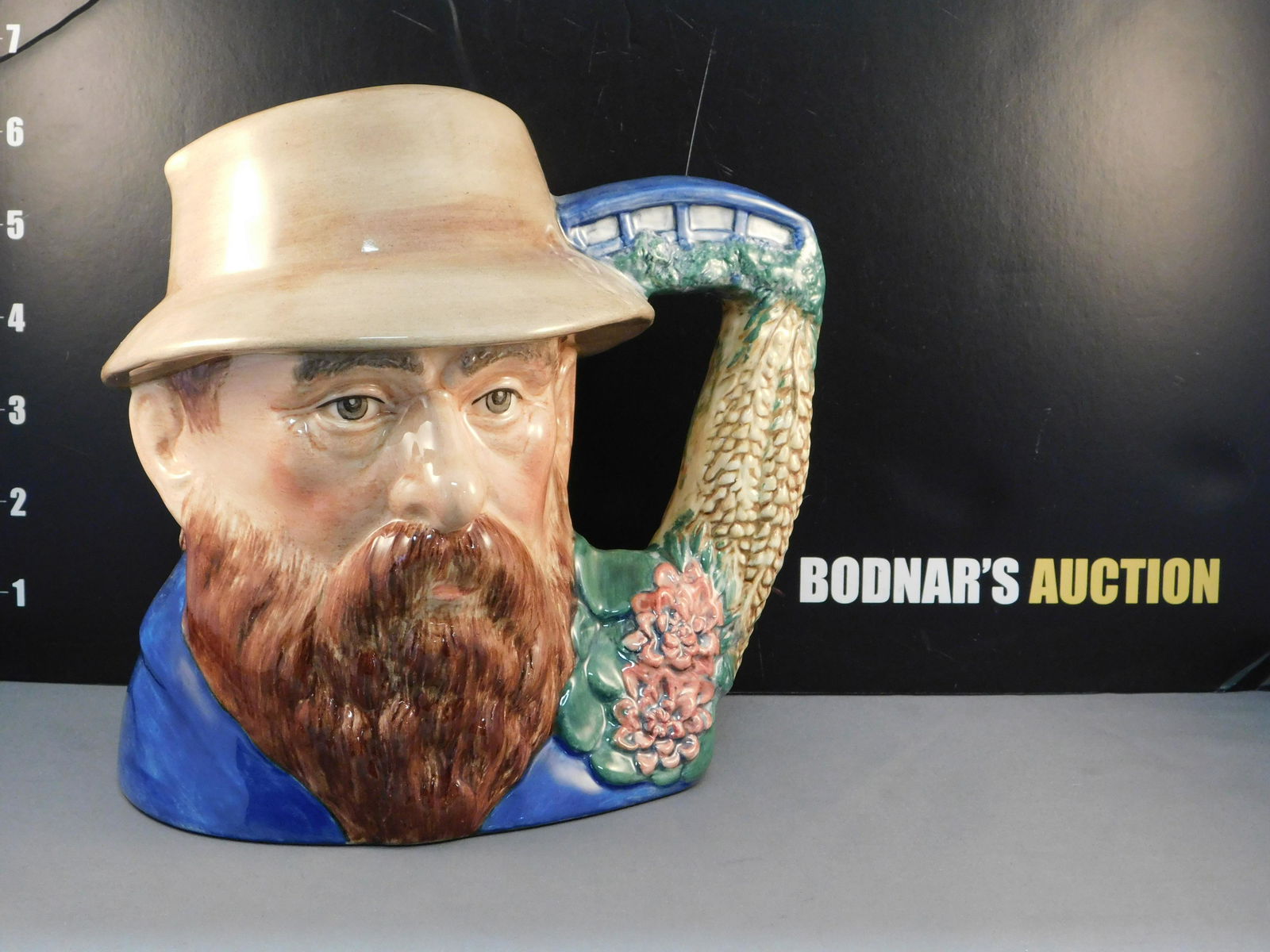Royal Doulton Claude Monet Character Jug: Royal Doulton Famous Artists Claude Monet Character/Toby Jug. D7150. Dated 2000. Small hairline crack and flea bite chip on rim. Measures 7" tall x 8" wide. All invoices must be paid within 24 hours o