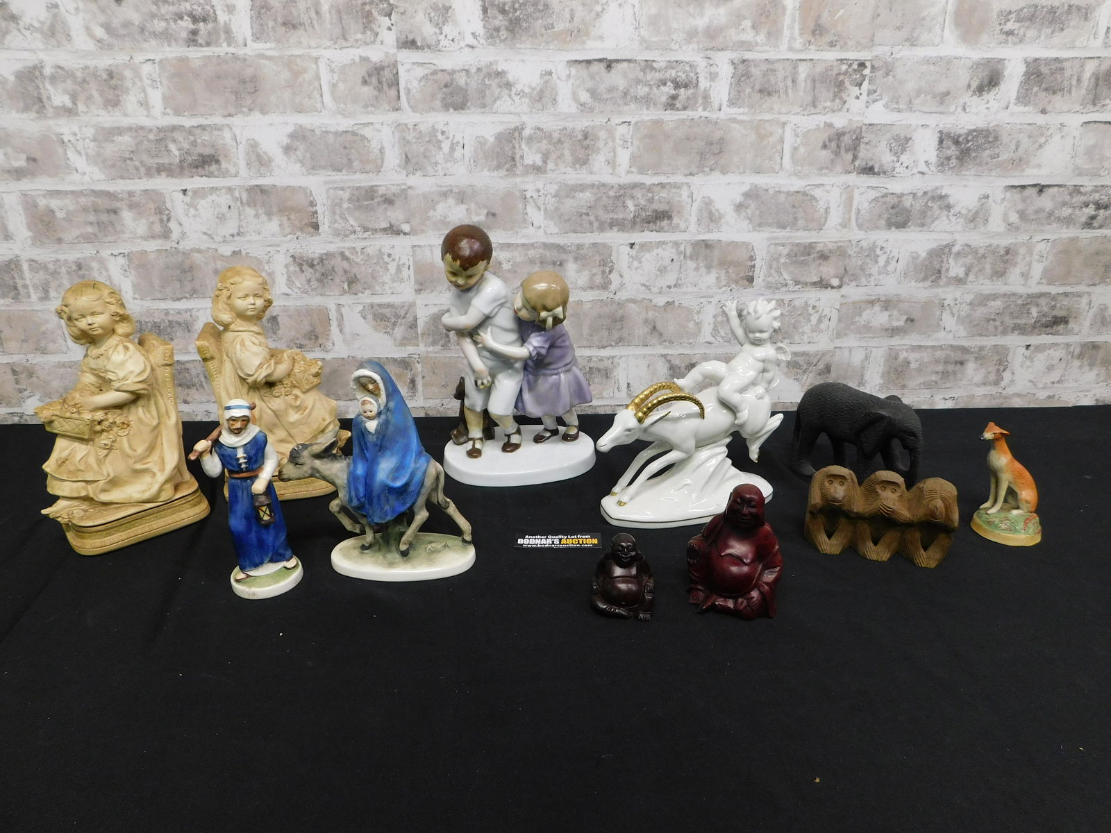 Group Lot of Various Figurines: Group Lot of Various Figurines. Includes Plaster Girls, Carved Wood Statues, English Staffordshire Dog, Goebel Figurines, German Deco Cherub, and AS-IS Children Figurine. You are bidding at a live sal