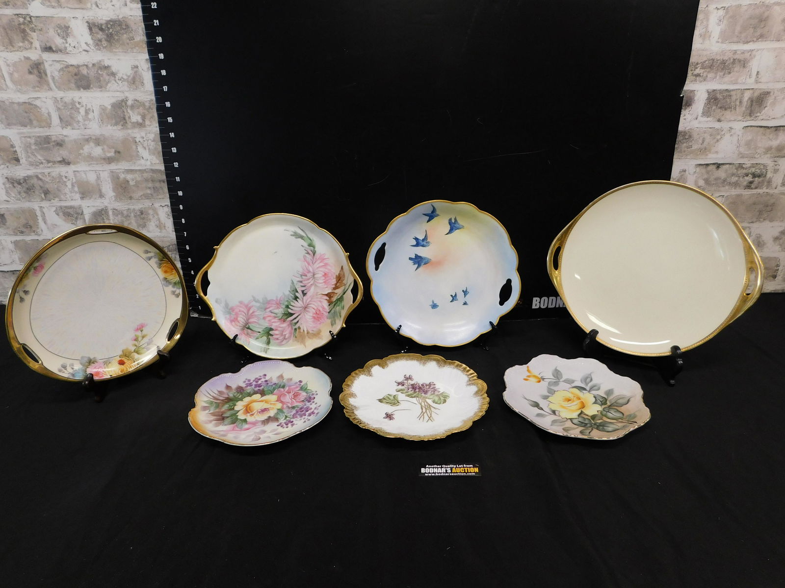 Lot of 7 Hand Painted Porcelain Plates: Lot of 7 Hand Painted Porcelain Plates. Includes Noritake, Limoges, Lefton and Black Knight. Black Knight plate has some wear to gold. You are bidding at a live sale. Please read the terms and conditi