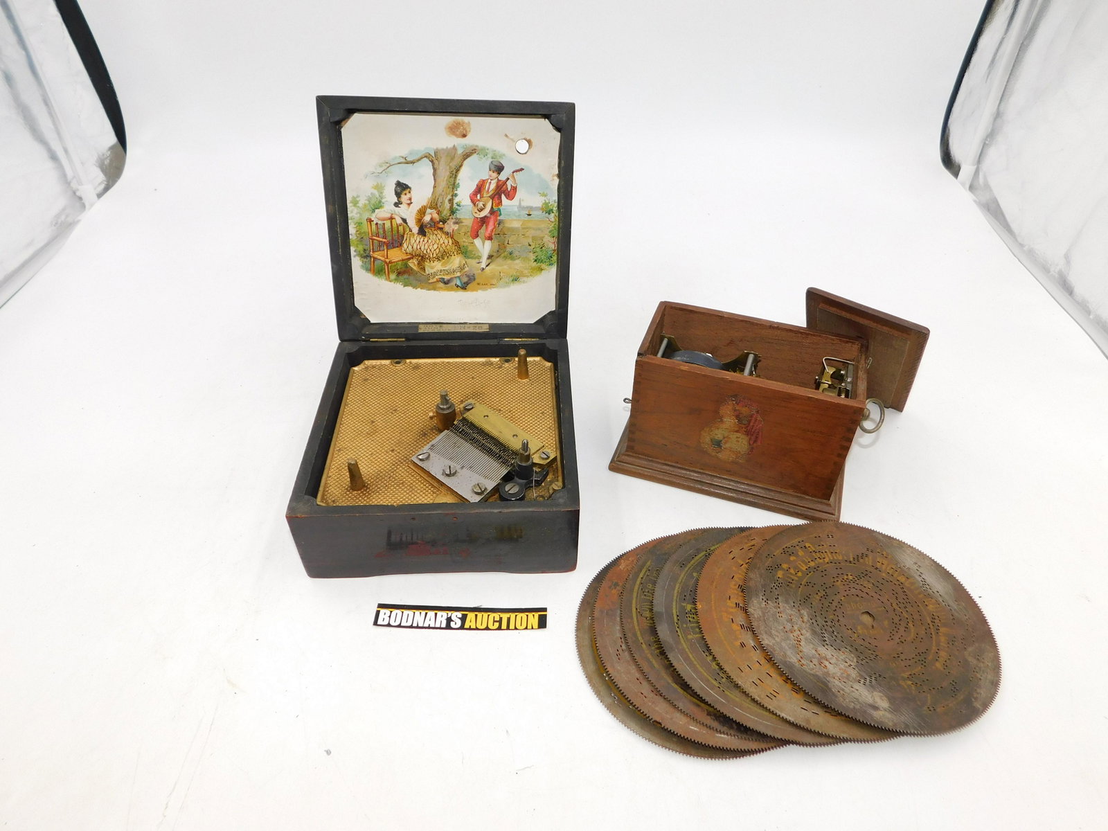 Lot of 2 Vintage Music Boxes: Lot of 2 Vintage Music Boxes including Symphonion - #28 Disk Player - Non Working. Has all teeth, Back hinge is loose and Comes with (6) 6" disks. Missing front latch and broken back of case at hinge.