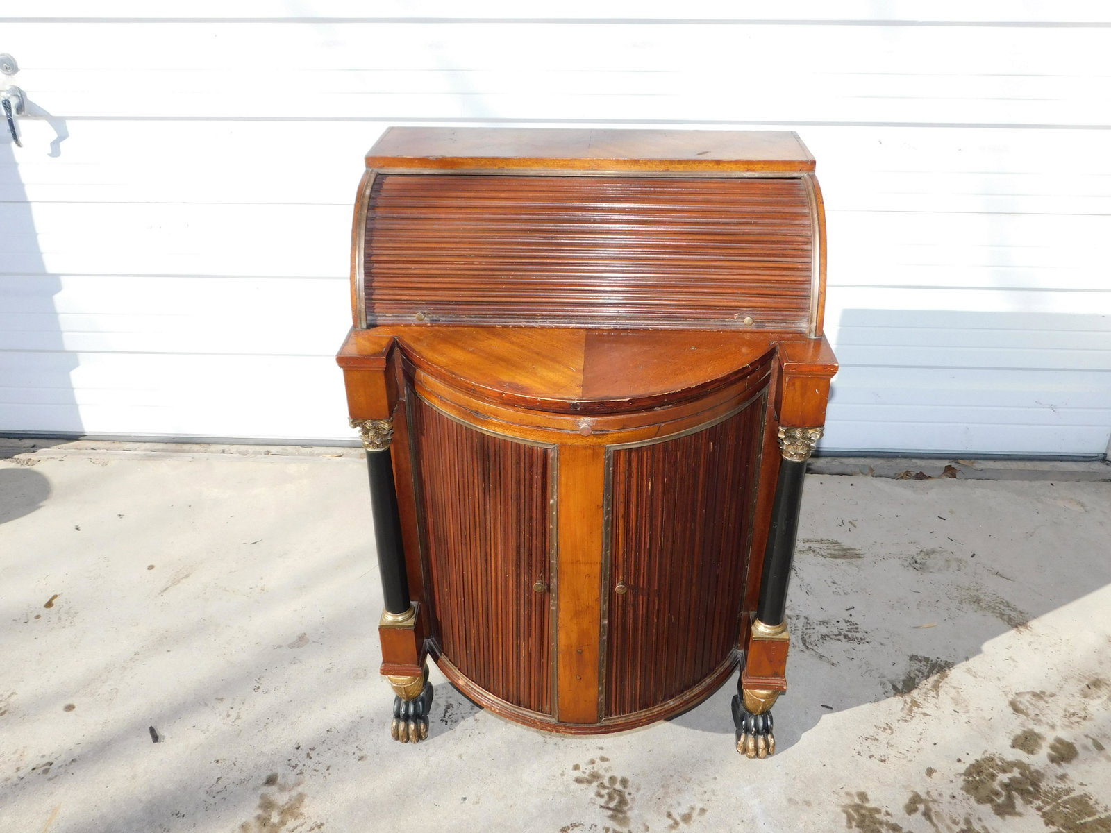 19th Century European Empire Rolltop Desk: Tall Footed Tamber Front Rolltop Desk. 19th Century European Empire. Has pullout desk. Has a carved sphinx decoration. Fair to good condition. Measures approx. 37" tall x 26.5" long x 22" deep. Please