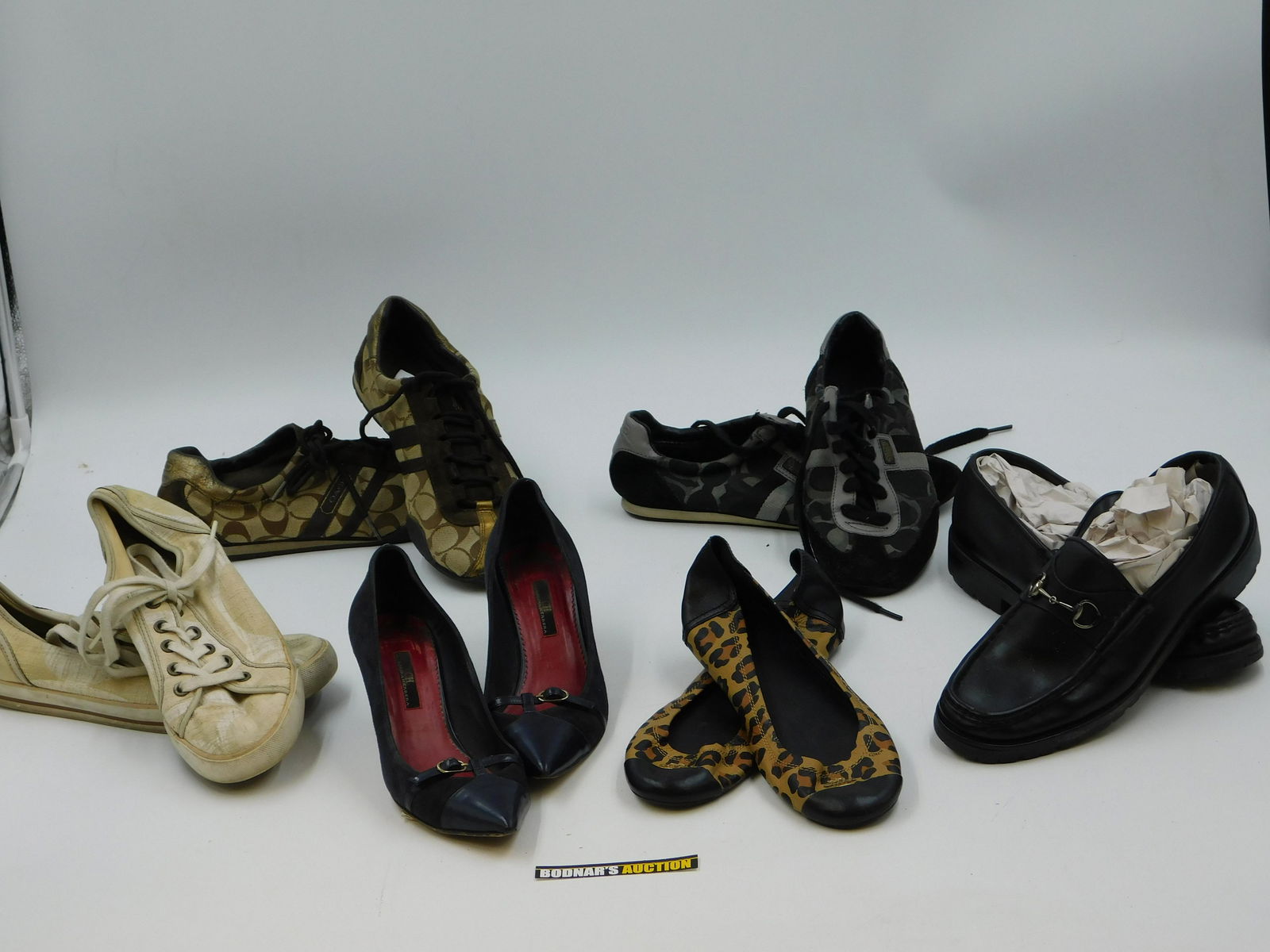 Lot of Designer Shoes: Lot of Designer Shoes including 3 Pairs of Coach Sneakers, Coach Flats, and Gucci Loafers. Used - Worn Condition. This sale will be broadcast live on sale day with full descriptions of each lot being