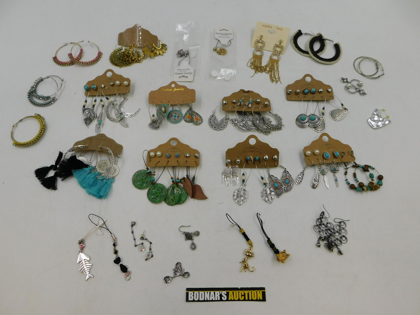 Lot of Fashion Earrings: Lot of Fashion Earrings. Most still on card. Including Gold and Silver Tone, Rhinestone, Knitted and More. This sale will be broadcast live on sale day with full descriptions of each lot being sold. A