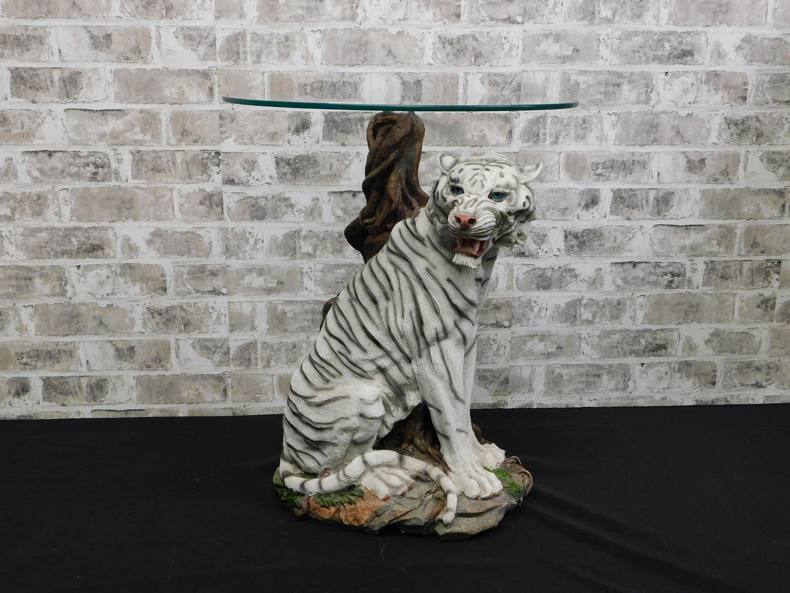 Resin Tiger End Table with Glass Top: Resin Tiger End Table with Glass Top. Measures 22" tall x 19" diameter. This sale will be broadcast live on sale day with full descriptions of each lot being sold. All items MUST be paid for within 24