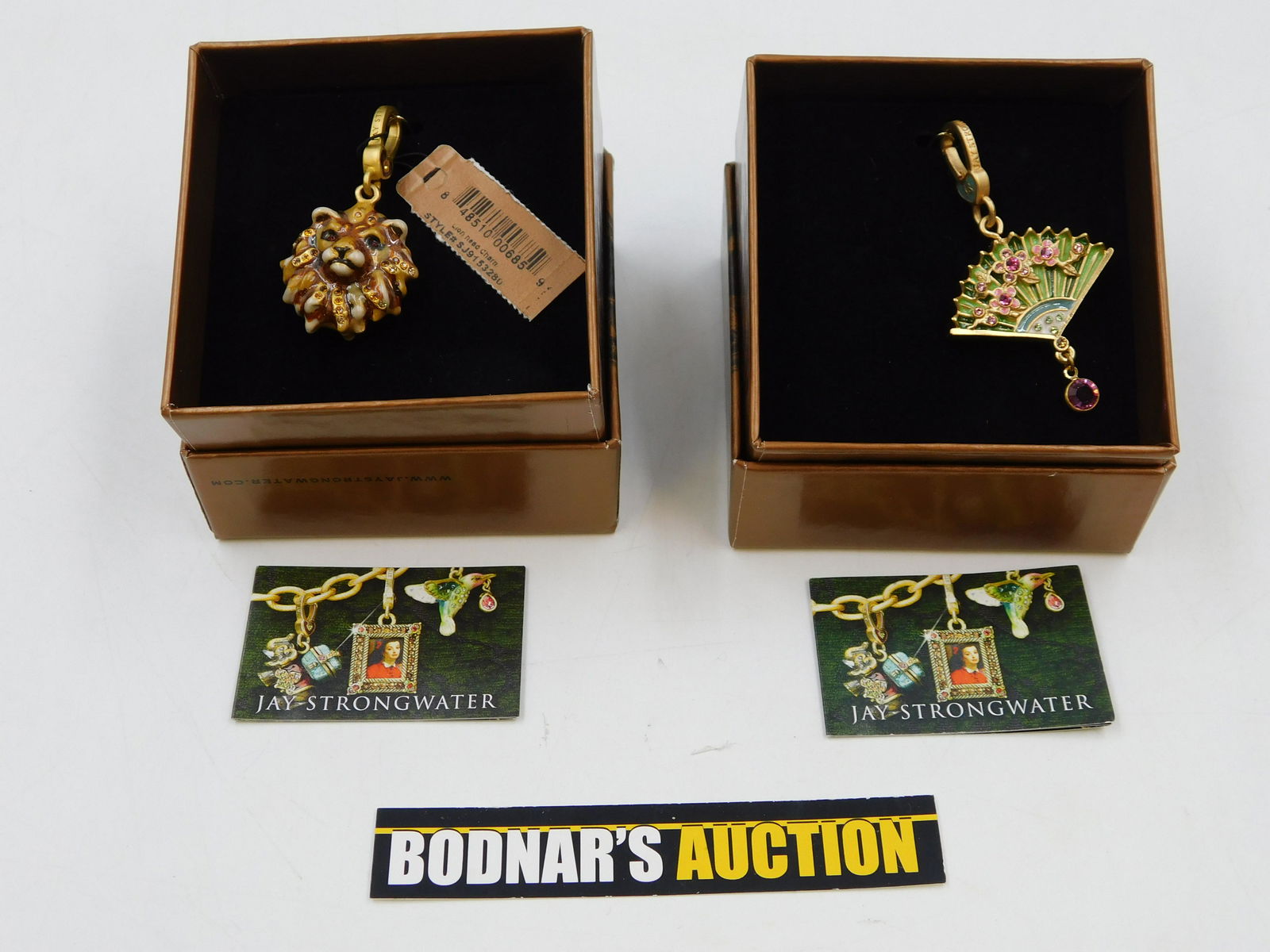 Lot of 2 Jay Strongwater Charms: Lot of 2 Jay Strongwater Charms including Chinoisene Fan Charm - Lucille and Lion Head - Bartholomew. There are no reserves in the entire sale. All invoices must be paid within 24 hours of the sale. A