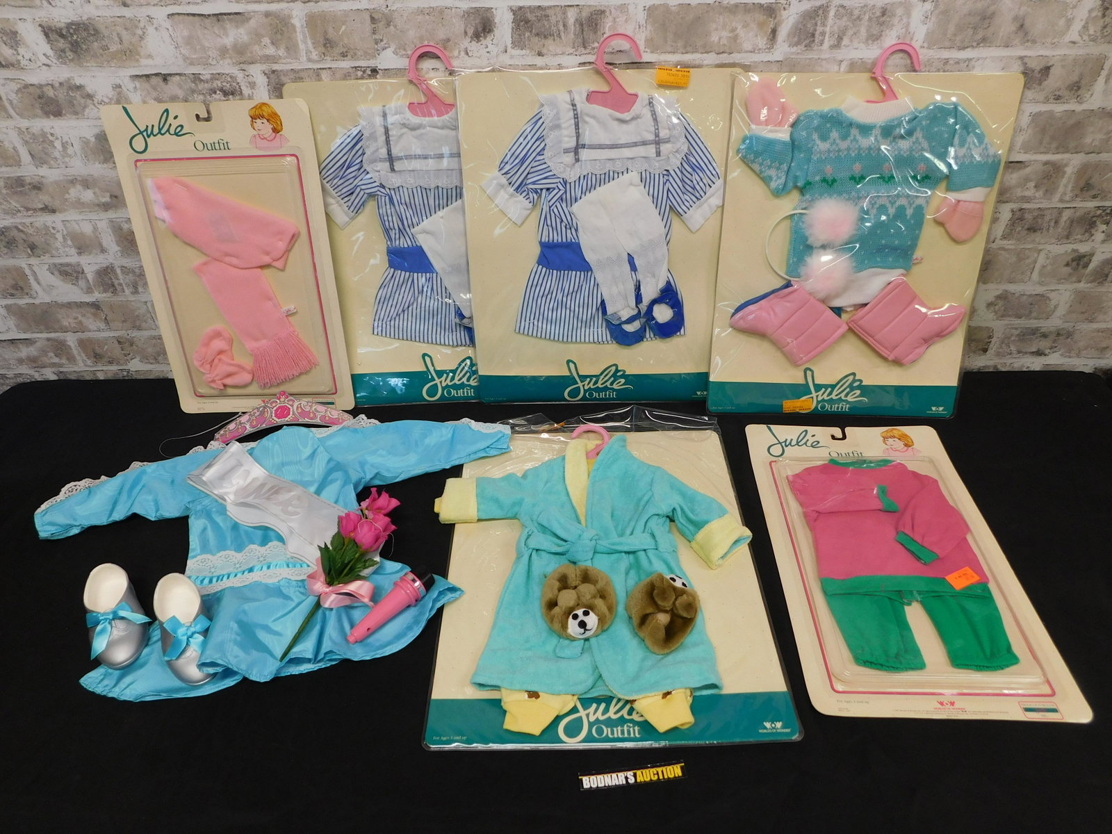 Lot of Julie Doll Outfits: Lot of Julie Doll Outfits. Many in Original Packaging. Appears to be 7 Outfits. This sale will be broadcast live on sale day with full descriptions of each lot being sold. All items MUST be paid for w