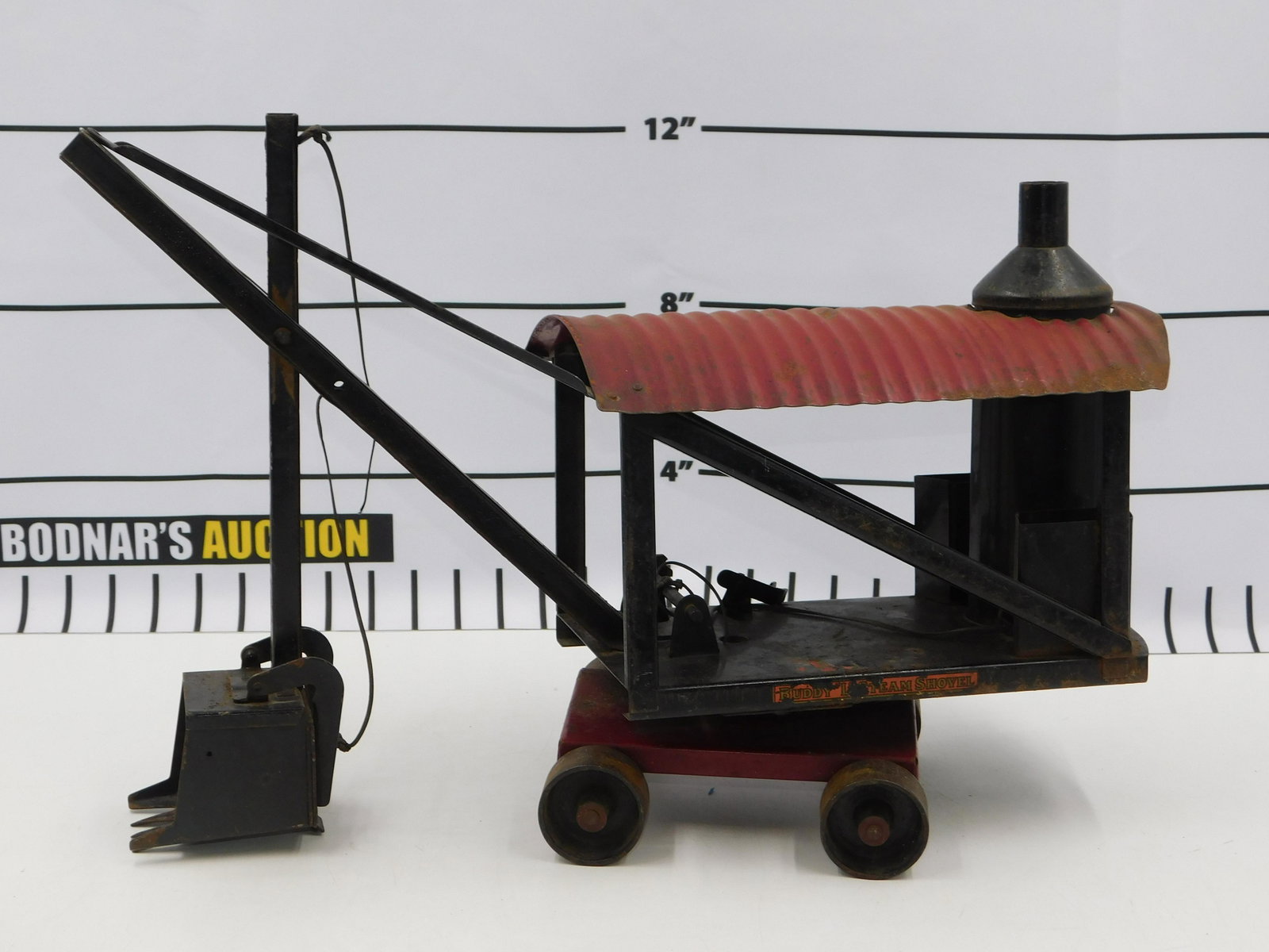 Pressed Steel Buddy L Steam Shovel: Pressed Steel Buddy L Steam Shovel. Front shovel needs to be restrung. Wobbley. Paint Loss and Minor Rusting. Measures 14" tall x 19" wide. All invoices must be paid within 24 hours of the sale. All i