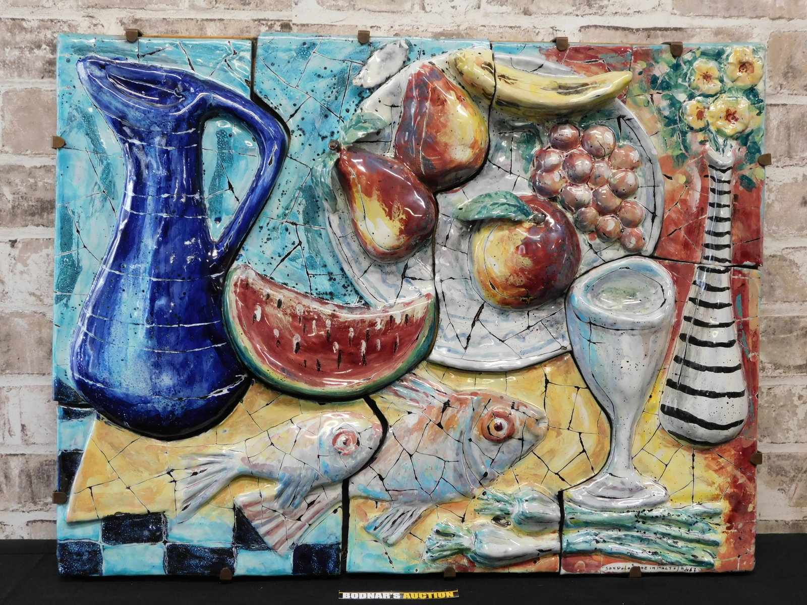 Framed Italian Porcelain Tile Plaque: Framed Italian porcelain tile plaque depicting fruit, fish and wine. Is in 7 parts, hand-painted and . Signed Sanpolo, made in Italy. Frame measures approx. 18.5" tall x 24, " wide. Please read the te