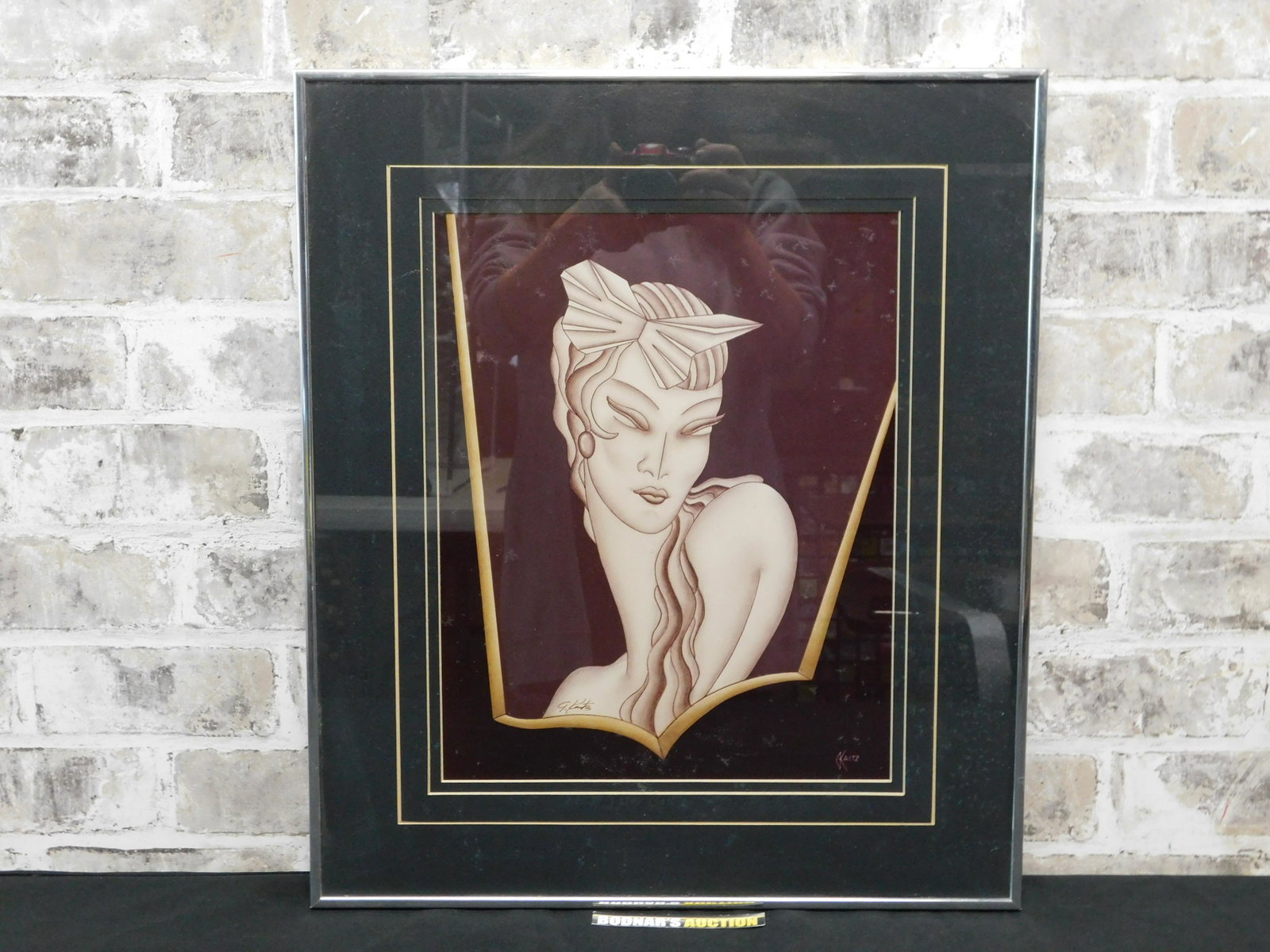 Framed Print on Board by Kaitz of an Art Deco Woman: Framed print on board by Kaitz of an Art Deco woman. Signed lower left. Frame measures approx. 19.5" tall x 17" wide. Please read the terms and conditions. This sale will be broadcast live on sale day