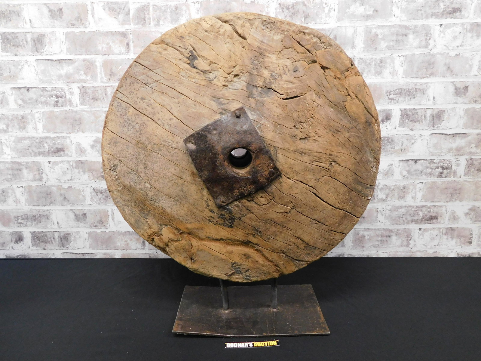 Industrial Wooden Wheel Sculpture: Industrial wooden wheel sculpture on iron base. Measures approx. 24" tall x 20" wide. Please read the terms and conditions. This sale will be broadcast live on sale day with full descriptions of each 