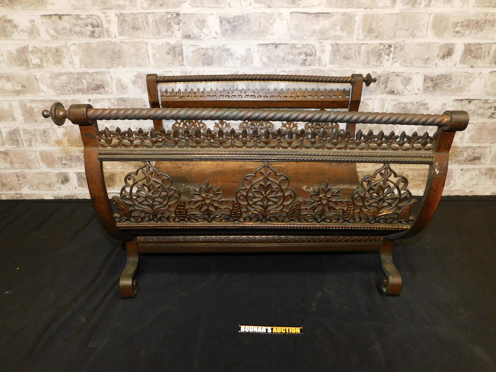Cast Iron, Bronze and Mixed Metal Fireplace Wood Holder: Cast Iron, Bronze and Mixed Metal Fireplace Wood Holder. Missing 2 decorative spindles. Measures 14" tall x 22.5" wide x 17" deep. Please read the terms and conditions. This sale will be broadcast liv