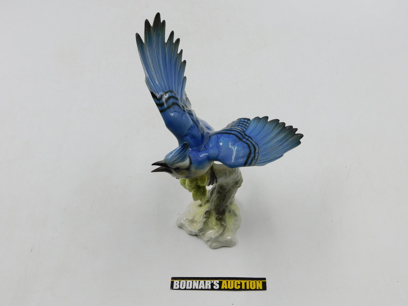 Hutschenreuther Blue Jay Bird Figurine: Hutschenreuther Blue Jay Bird Figurine perched on a tree stump. Paper Label marked 2531/2f. Measures approx. 9.5" tall, 7" wide. All invoices must be paid within 24 hours of the sale. All items are sh