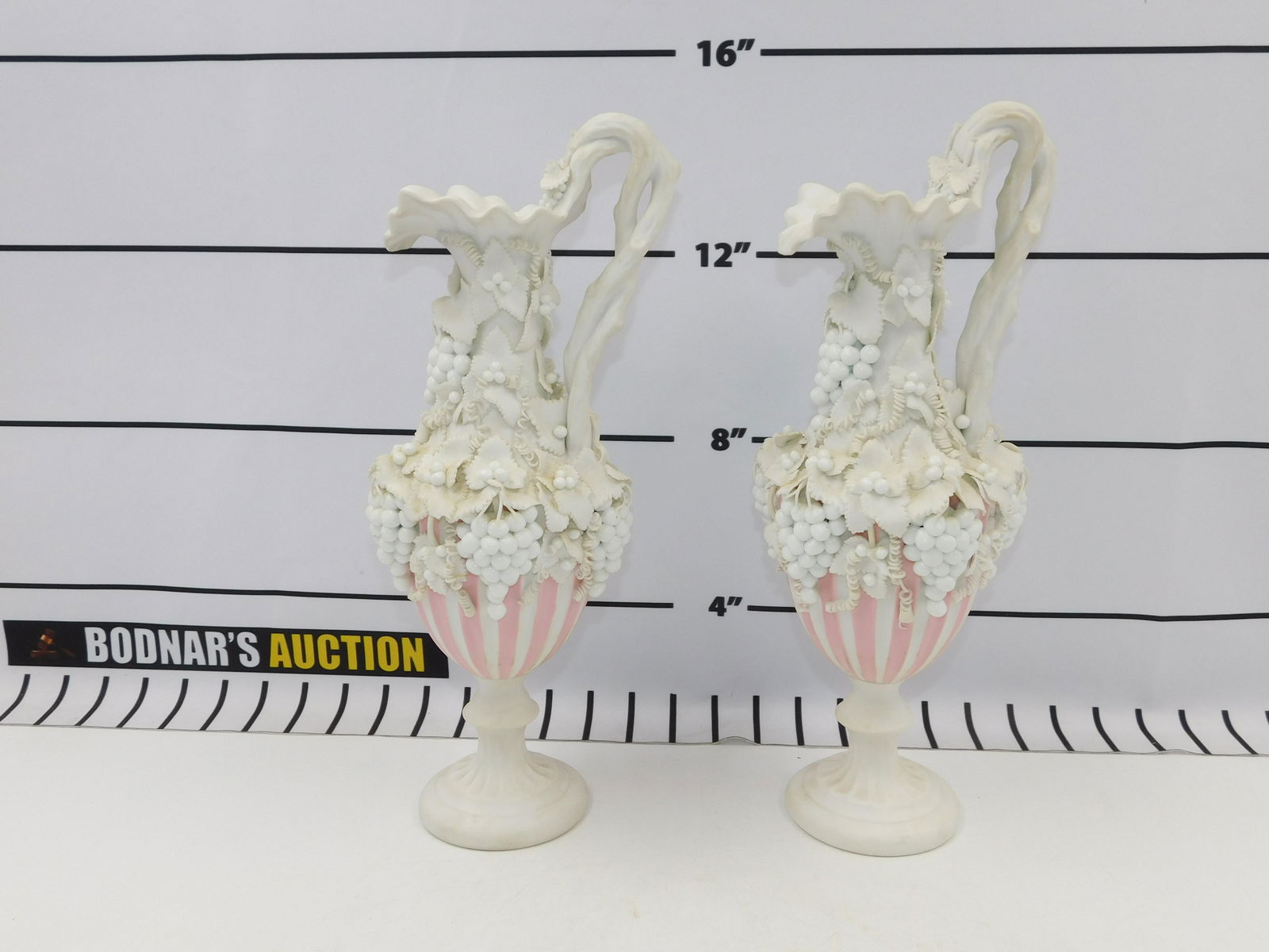 Pair of 19th Century Old Paris Urns: Pair of bisque/French Old Paris Urns with minor loss to the applied decoration. Measures approx. 14" tall, 5" wide. All invoices must be paid within 24 hours of the sale. All items are shipped with Li