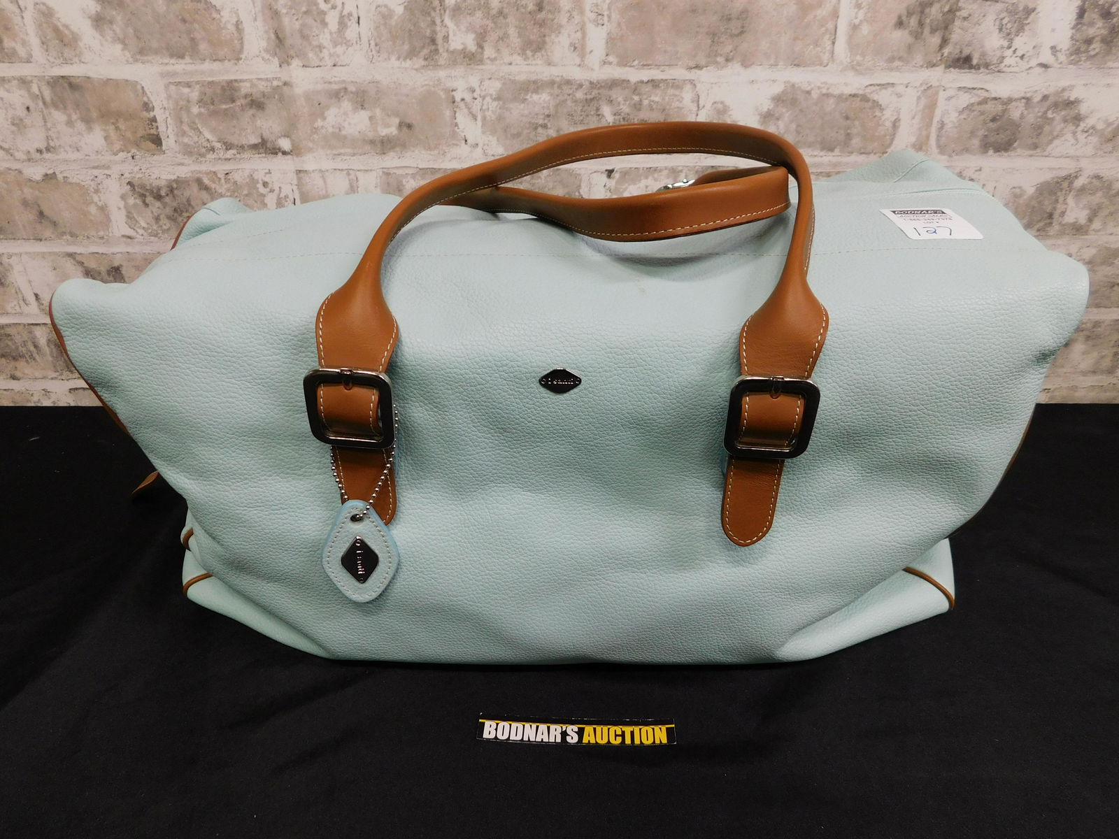 I Santi Leather Travel Bag: I Santi Leather Travel Bag. A couple of scuffs present on the leather. Please read the terms and conditions. This sale will be broadcast live on sale day with full descriptions of each lot being sold.