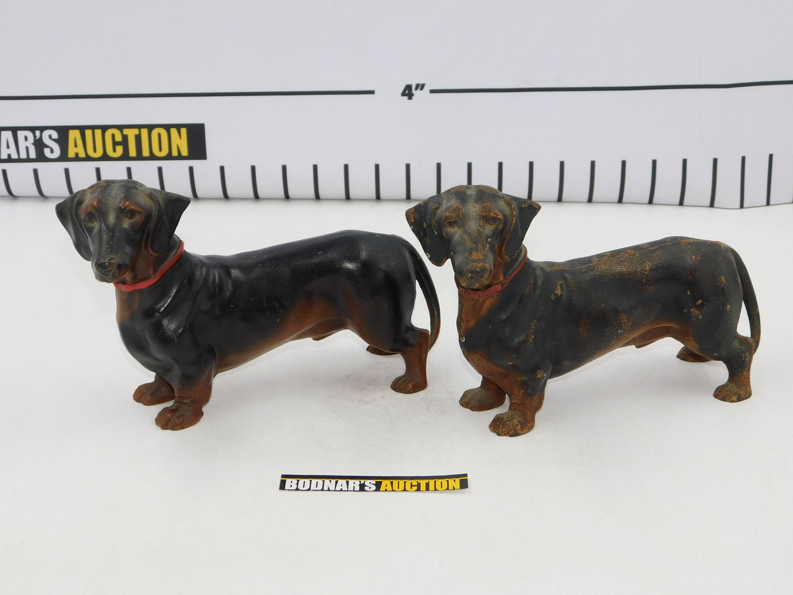 Pair of Cast Iron Dachshund Dog Doorstops: Pair of Vintage Cast Iron Cold Painted Dachshund Dog Doorstops. Marked Made in USA. One in near mint Condition and the other has some paint loss. Measures 6" tall x 9.5" long x 3" deep. All invoices m