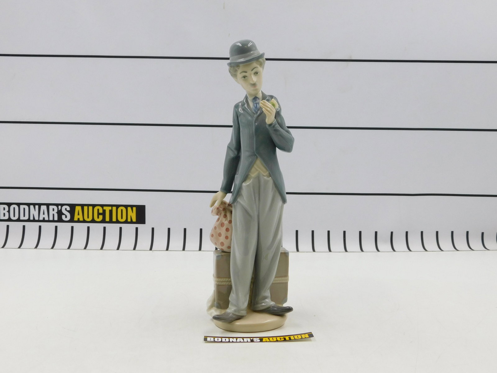 Lladro "Charlie The Tramp" Charlie Chaplin Figurine: Lladro "Charlie The Tramp" Charlie Chaplin Porcelain Figurine. #5233. Missing Cane. Measures 11.25" tall. All invoices must be paid within 24 hours of the sale. If you need your items shipped, we are 