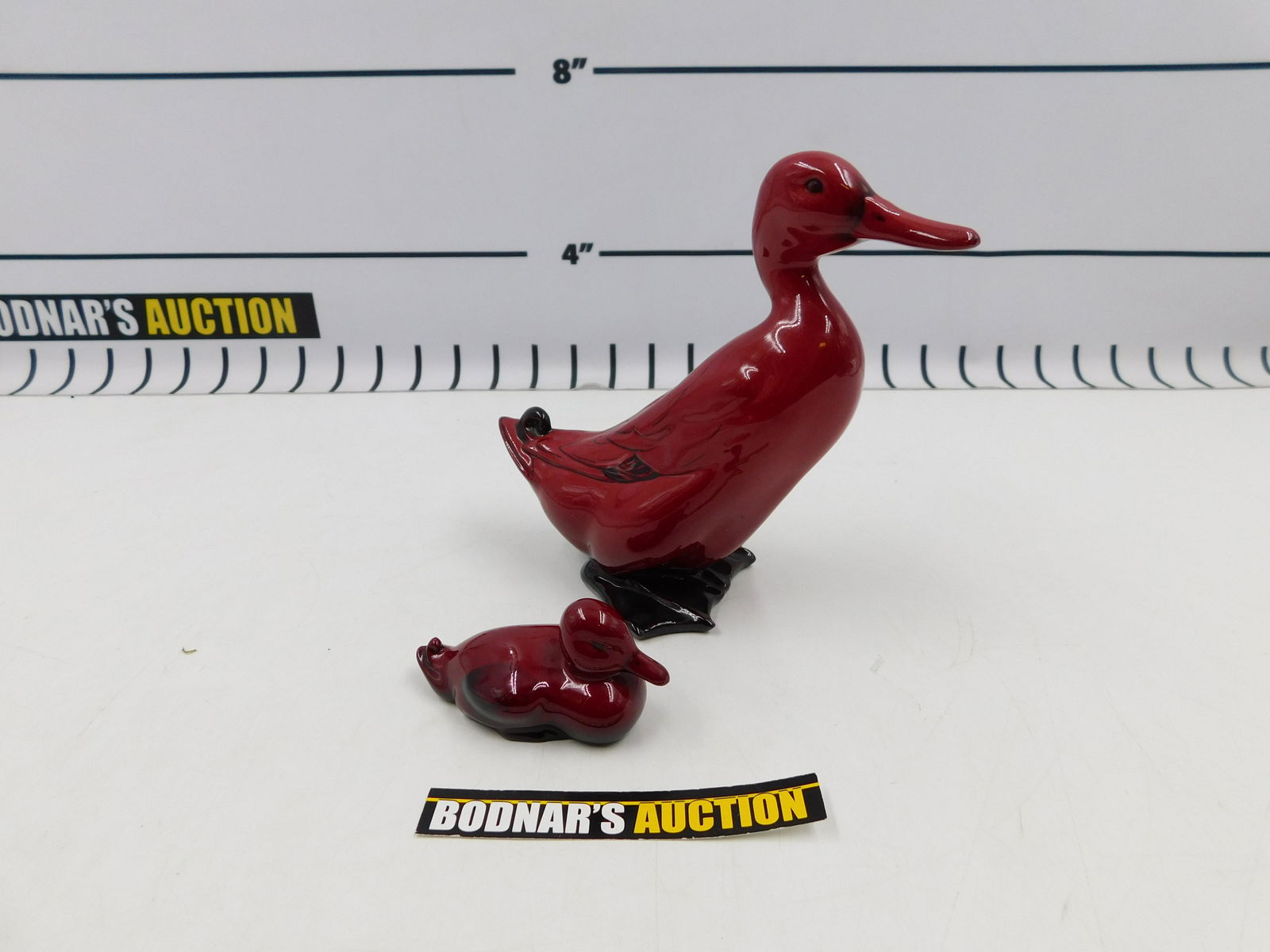 Lot of 2 Royal Doulton Flambe Duck Figurines: Lot of 2 Royal Doulton Flambe Duck Figurines measuring 1.75" and 6.25" tall. All invoices must be paid within 24 hours of the sale. If you need your items shipped, we are using Liveauctioneers Live Sh