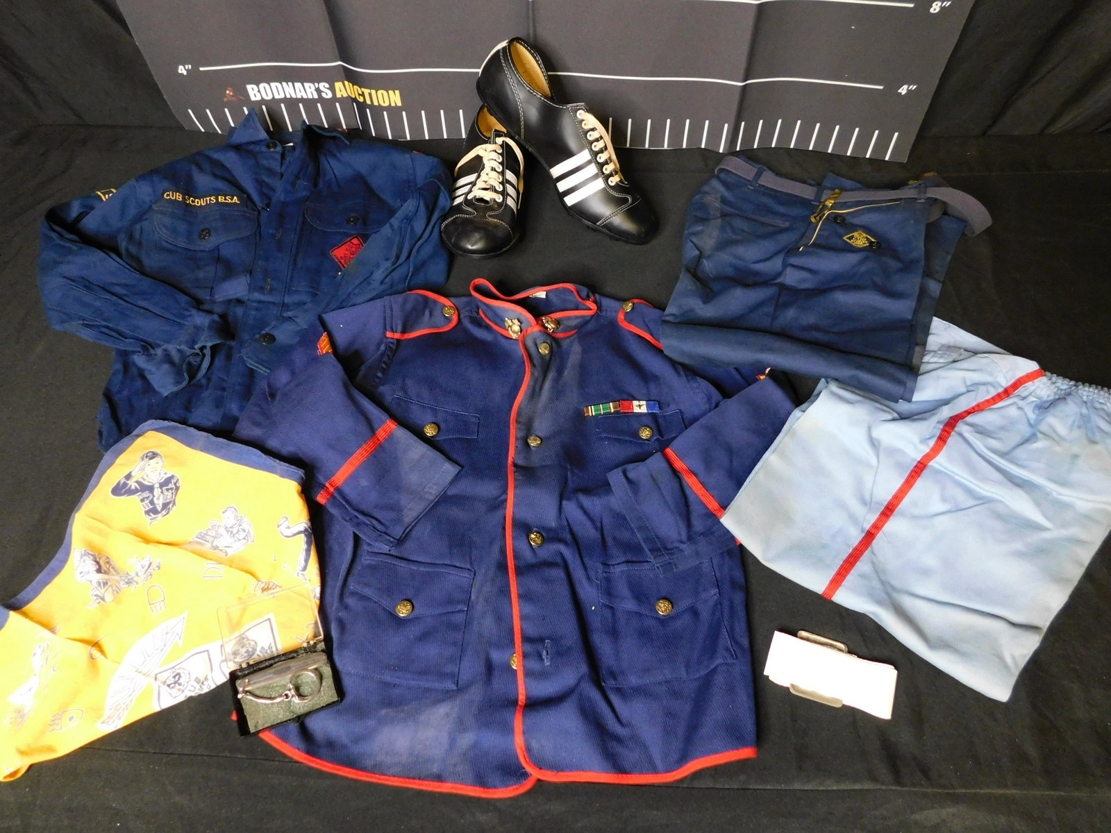 Lot with Cub Scout Uniforms and a Pair of Cleats: Lot with Cub Scout Uniforms and a Pair of Cleats. All invoices must be paid within 24 hours of the sale. All items are shipped USPS or UPS and will be billed separately. A $12 handling fee is added to