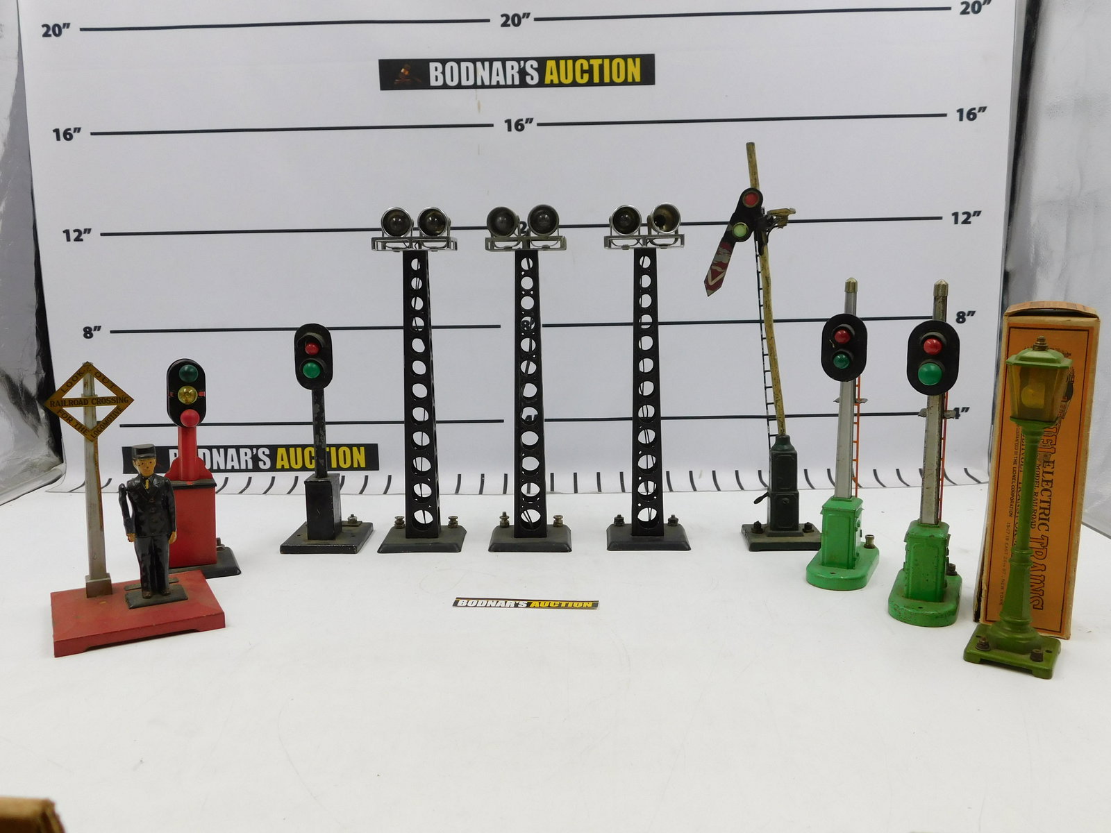 Lot of O Gauge Train Accessories - Mixed Brands: Lot of O Gauge Train Accessories including Lionel Signal Towers, 3 Marx Dual Flood Lights, Lionel Lamp Post #56 - Box has wear, and Lionel Flagman Crossing #1045 and More. All invoices must be paid wi