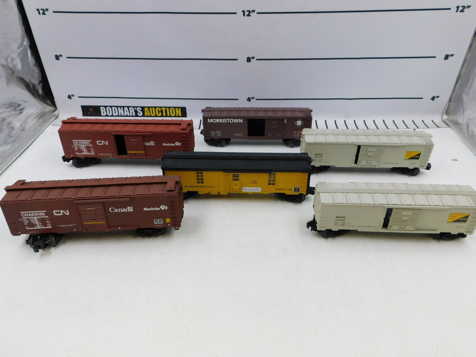 Lot of O Gauge Rolling Stock: Lot of O Gauge Rolling Stock including (2) CN Boxcars, Moorestown & Eerie Box Car ,NYSW Lighted Tool Car 320, and (2) ACFX Box Cars - Customized. Please read the terms and conditions. This sale will b