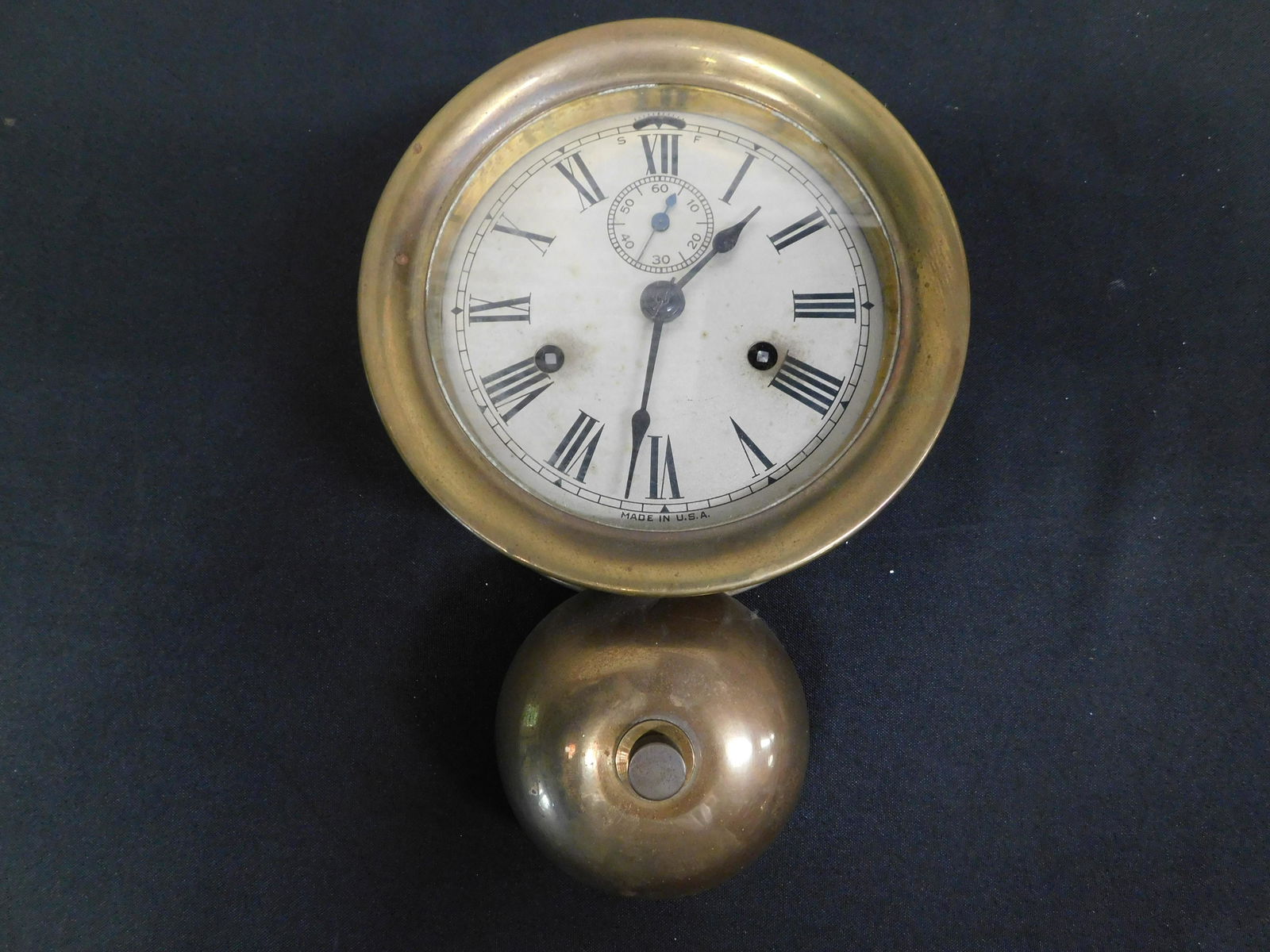 Ship's Brass Clock with Bell: Ship's brass clock with bell signed made in USA, untested. Measures 11 inches long by 7 inches in diameter. All invoices must be paid within 24 hours of the sale. This auction is Local Pick Up, Shippi