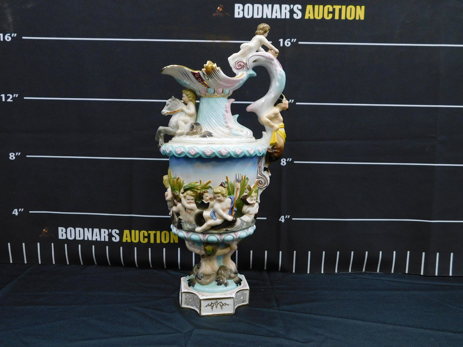Capodimonte Hand Painted Pitcher with Cherub Motif: Capodimonte Hand Painted Pitcher with Cherub Motif. Marked on Bottom R inside a Square. Measures 16" tall x 7" wide. All invoices must be paid within 24 hours of the sale. This auction is Local Pick U