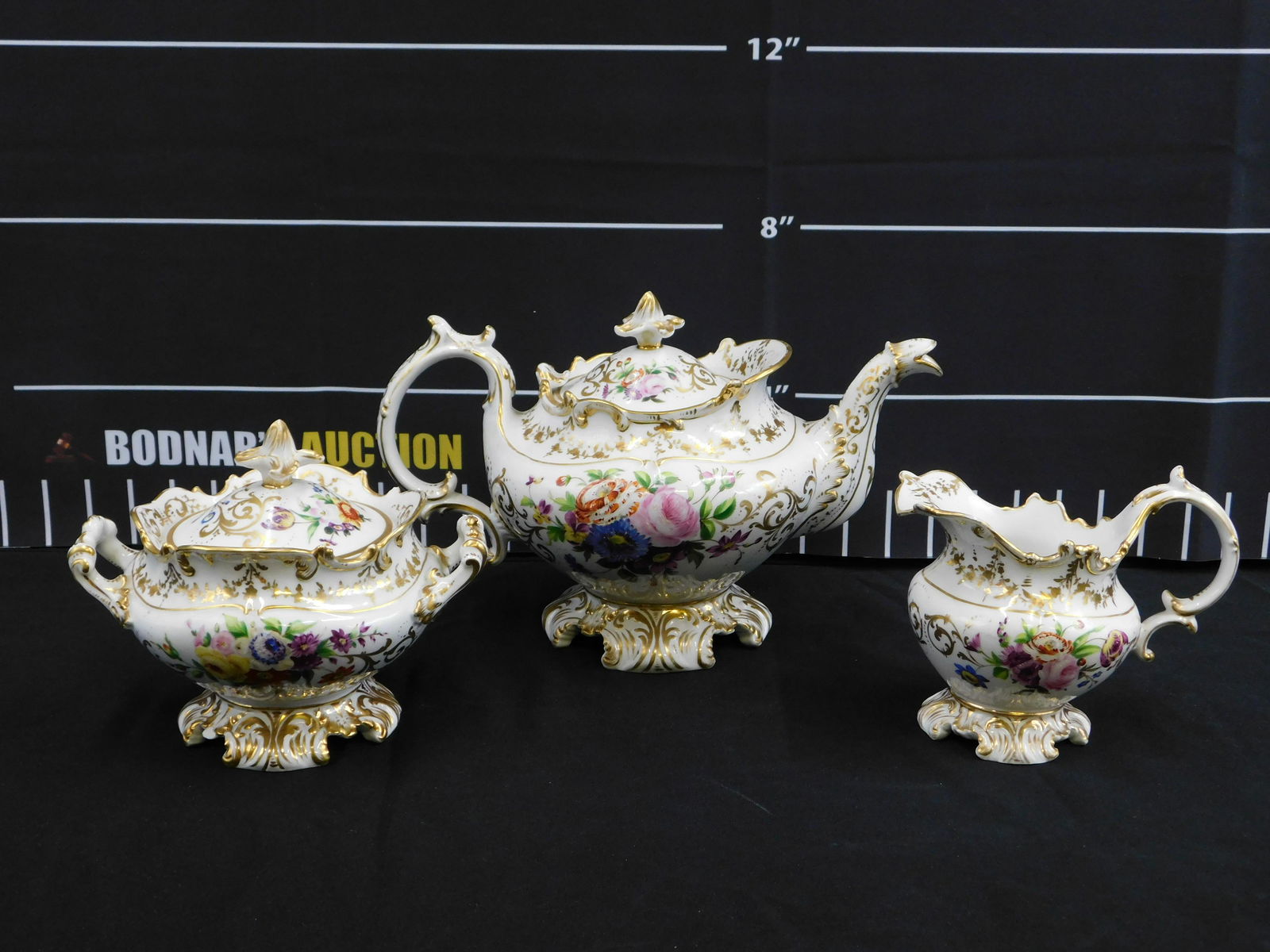 Hand Painted Porcelain Teapot, Creamer and Sugar: 19th Century Hand Painted Porcelain Teapot, Creamer, and Sugar. The sugar bowl has a couple of chips. Marked JP. The largest measures 7.5" tall x 12" wide. All invoices must be paid within 24 hours of