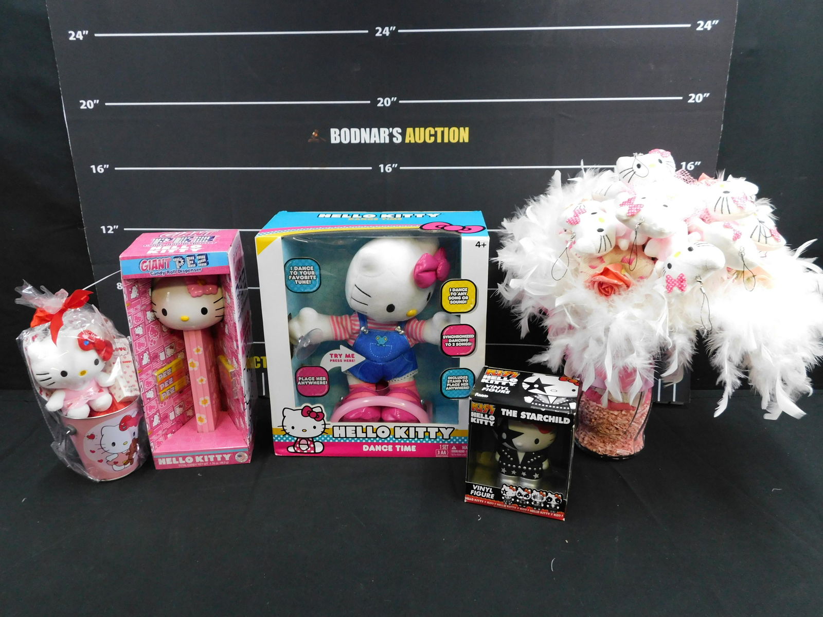 Lot of Hello Kitty Items: Lot of Hello Kitty Items including Giant Pez, Flower Arrangement, Plush in Pail, The Starchild KISS Figure, and Dance Time. Most come with the original packaging. Please read the terms and conditions.