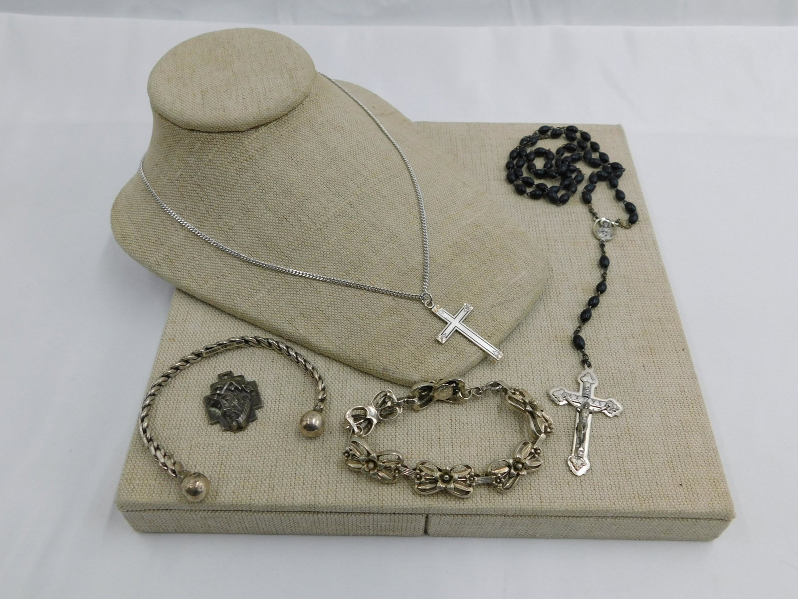 Lot of Sterling Silver: Lot of Sterling Silver including Mexican Silver Bracelet, Sterling Pettell's Flower Bracelet, Religious Pendant, Italian Rosary, and Sterling Cross on Silver tone Chain. All invoices must be paid with