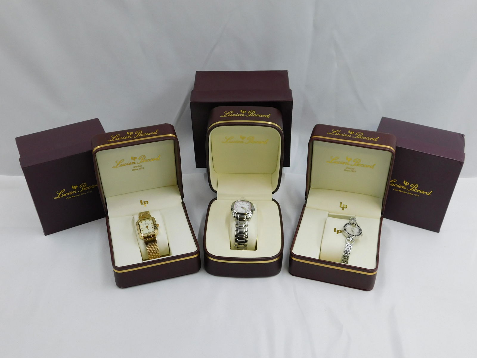Lot of 3 Lucien Piccard Ladies Watches: Lot of 3 Lucien Piccard Ladies Watches including Gold Tone Watch with Diamond Chips in Face, Silver Tone with Diamond Chips in Face, and Silver Tone with Black Rhinestones and Diamond Chips in the fac