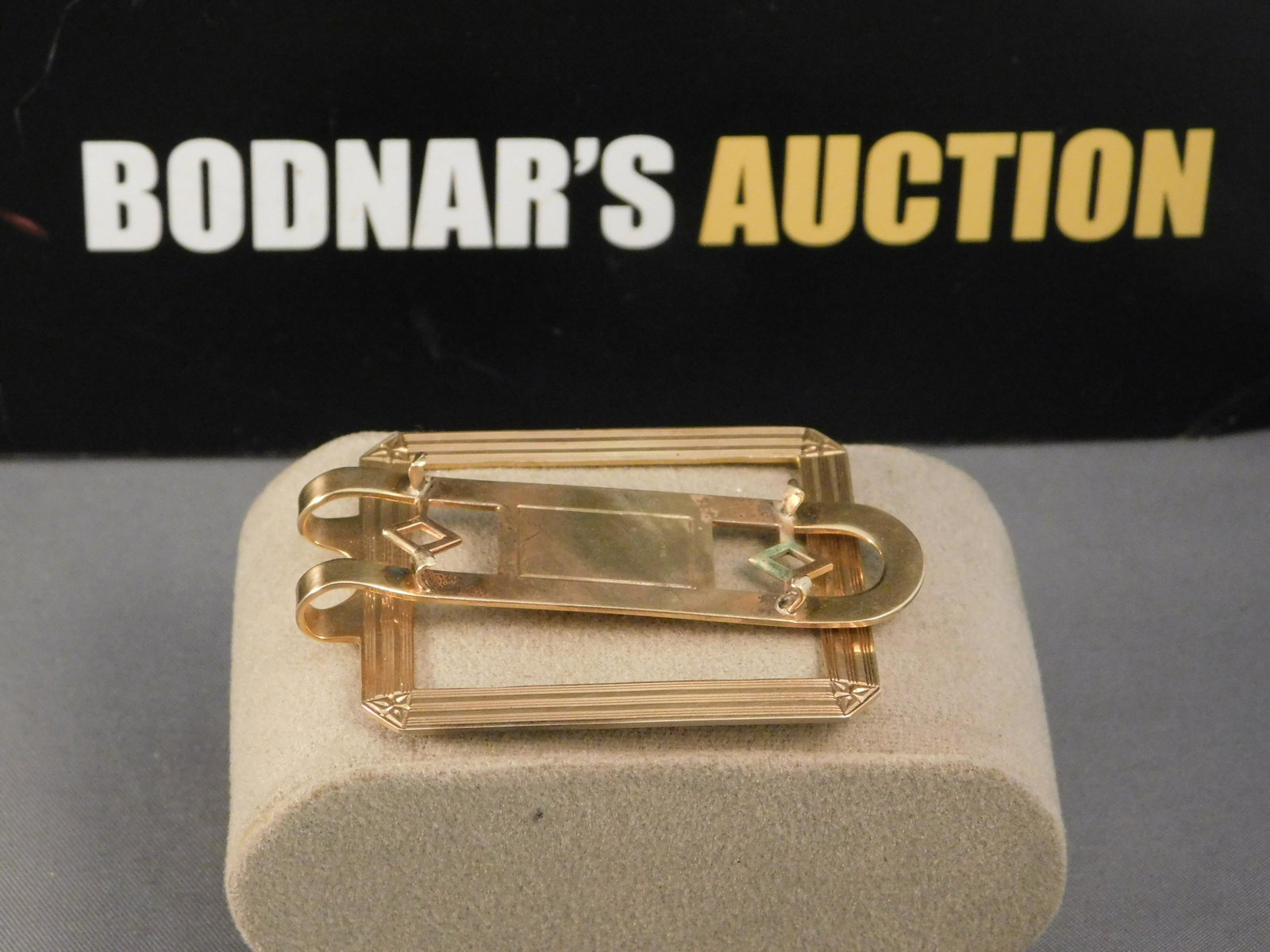 14K Gold Money Clip: 14K yellow gold Money clip. It appears to be missing a stone or something that was held in the center as there are prongs with nothing inside. Is marked and measures approx. 2 1/4". Weighs approx. 14g