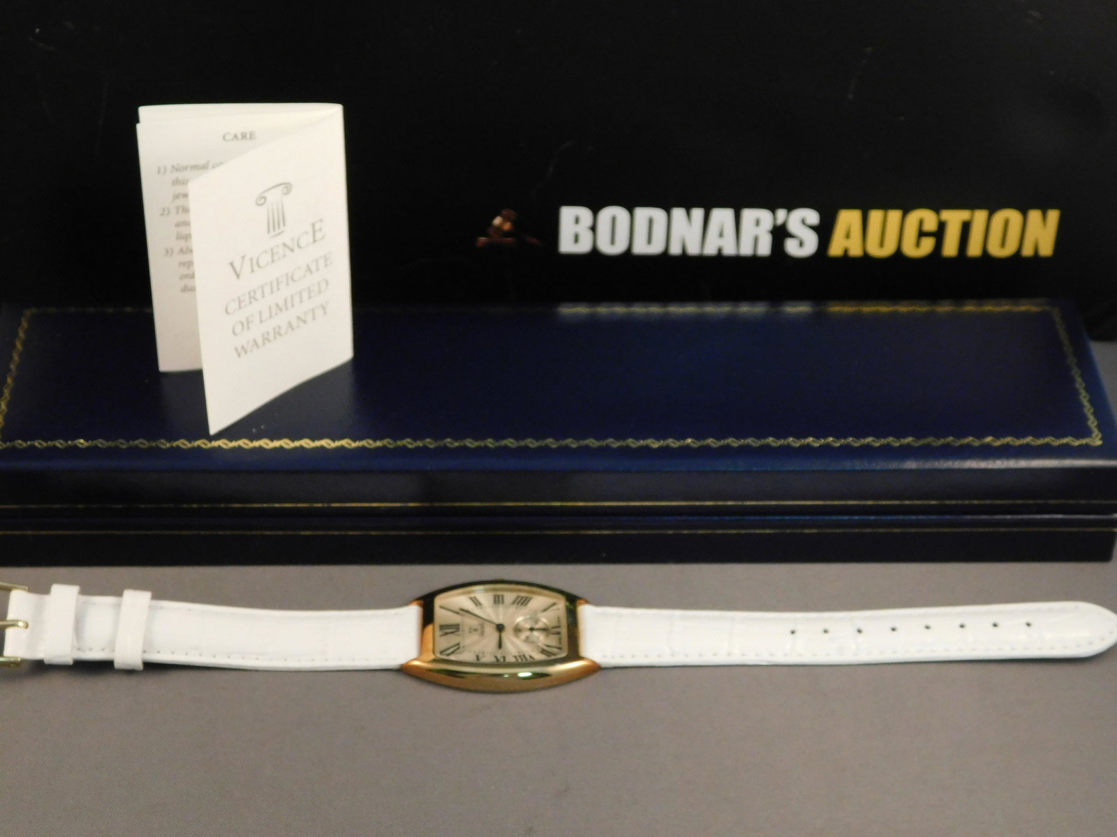 Vicence 14K Gold Ladies Watch: 14K yellow gold Vicence ladies watch with a 14K yellow gold bezel and case back and a white leather band. Has the original box and paperwork. Measures approx. 9". Is marked on the back of the case. Un