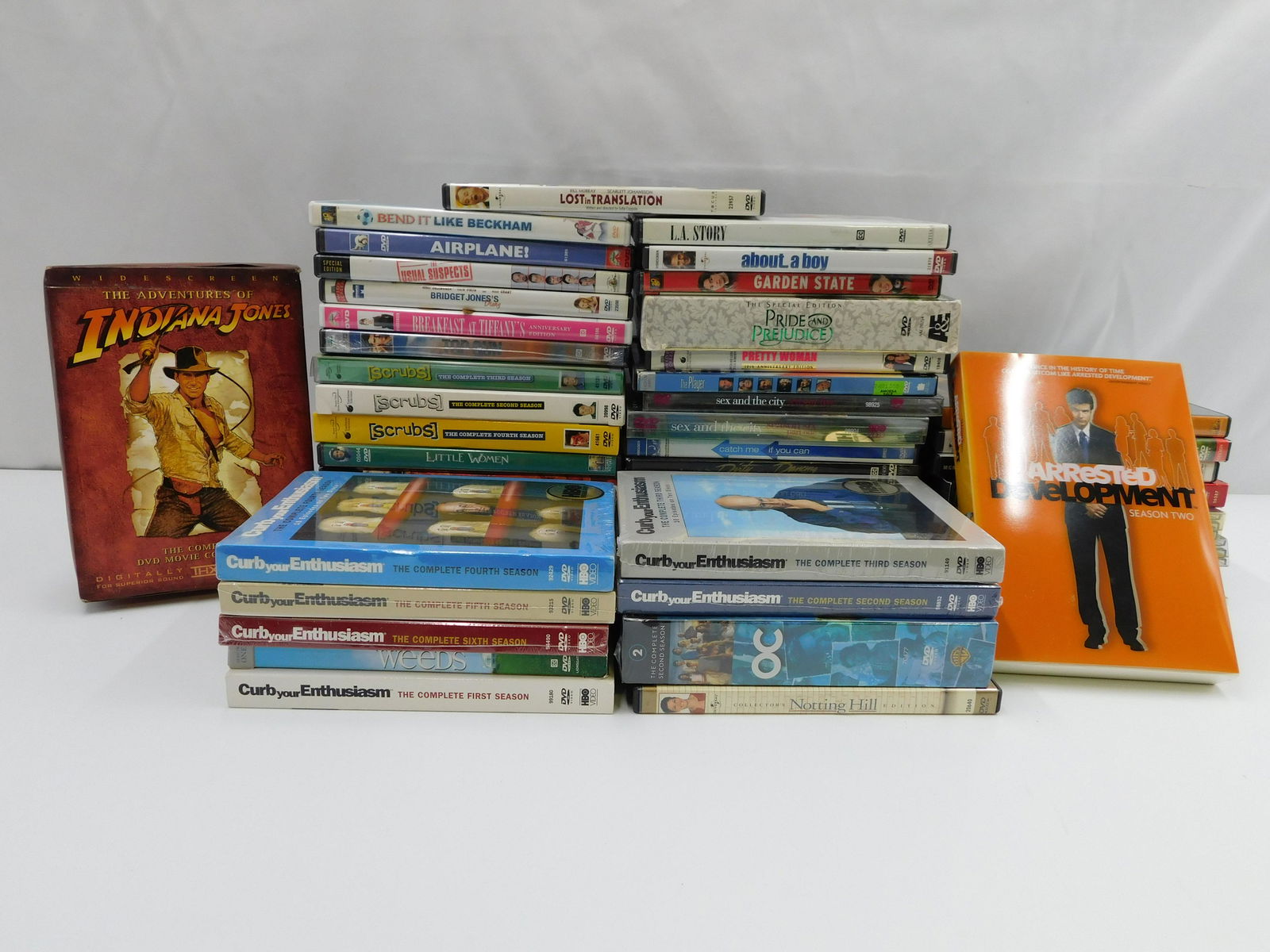 Large lot of DVDs, Movies and TV Show Box Sets: Large lot of DVDs, Movies and TV show box sets including Sex in the City, Curb your Enthusiasm, OC, Indiana Jones, Top Gun, and more, some are factory sealed. All invoices must be paid within 24 hours