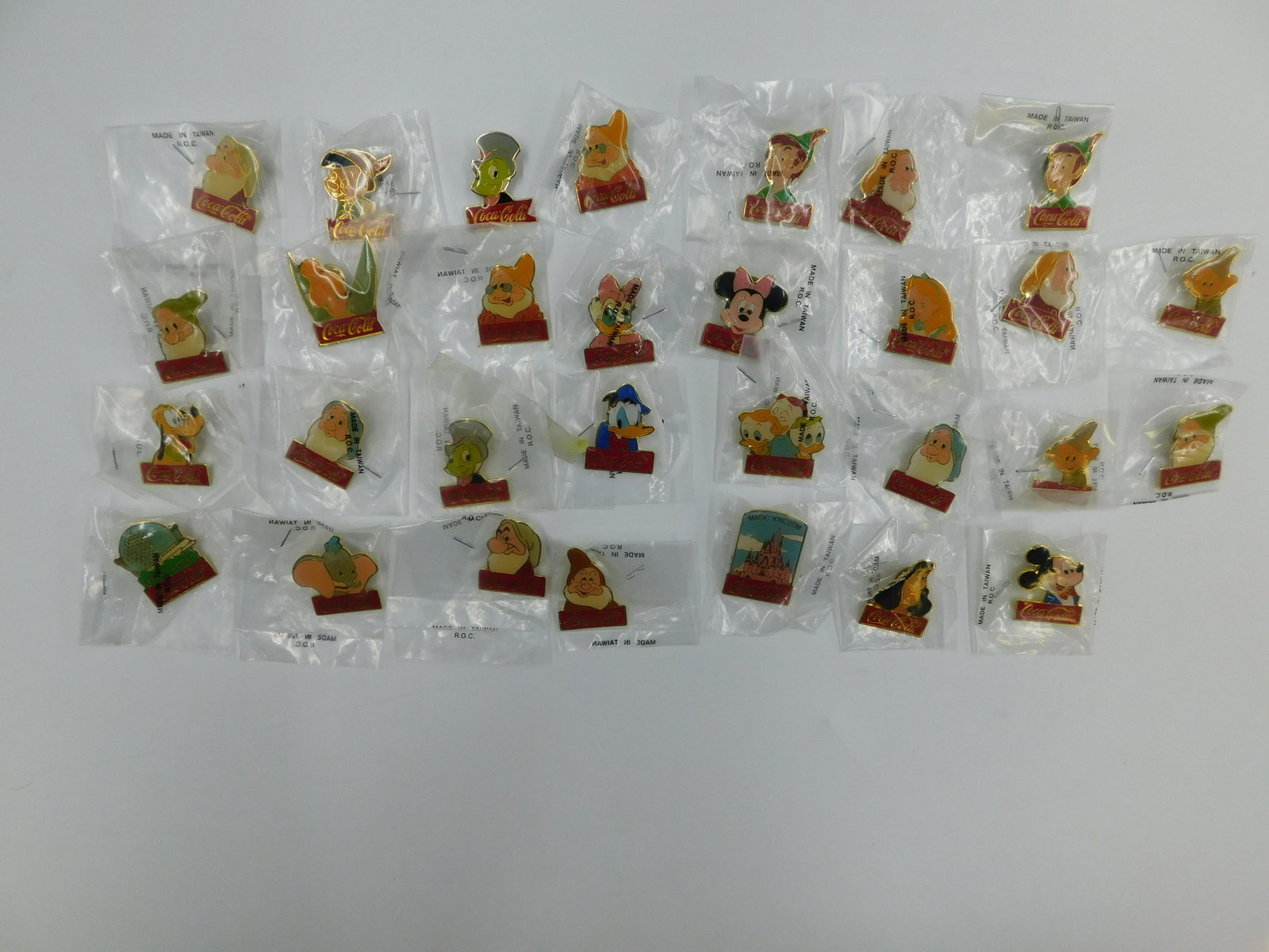 Lot of 30 Disney Coca Cola Pins: Lot of 30 Disney Coca Cola Pins. All but 1 are sealed. Some duplicates includes. Some characters included are Donald Duck, Dumbo, Dopey, Grumpy, Jiminy Cricket, Pinocchio, Pluto, Minnie Mouse and More
