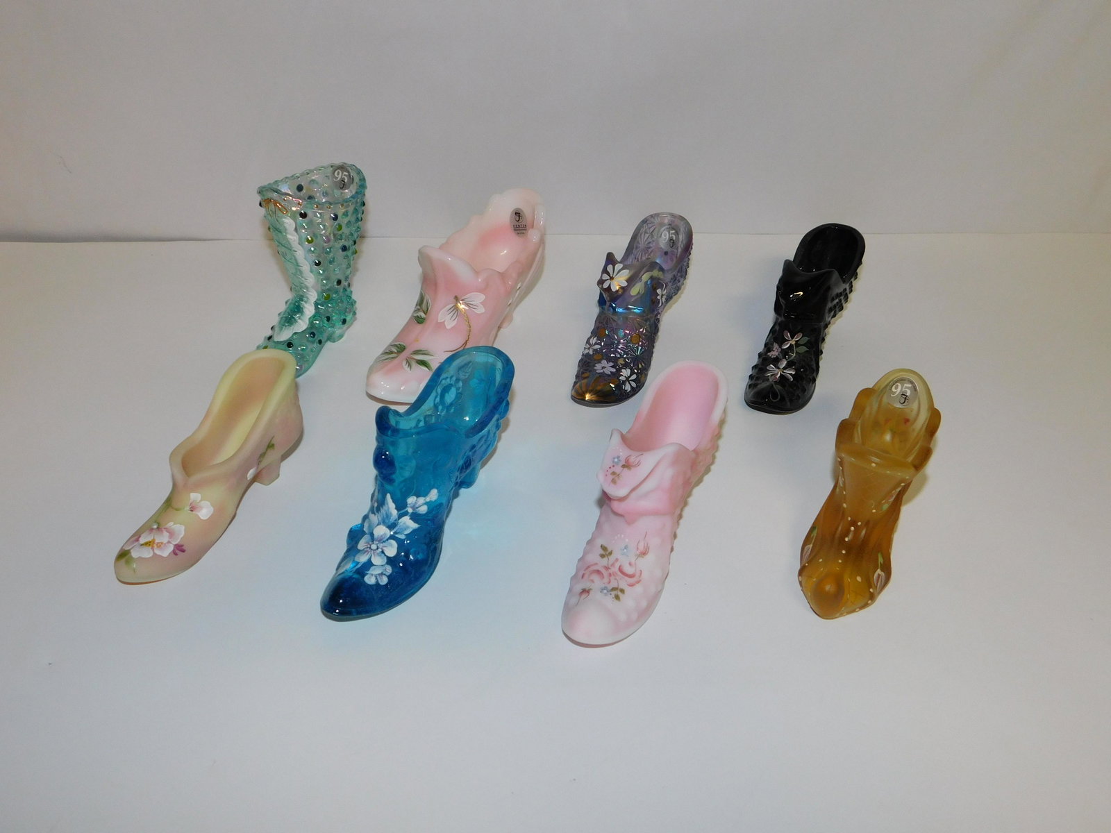 Lot of 8 Fenton Slippers and Boots: Lot of 8 Fenton Slippers and Boots. All are artist signed. Three come with boxes. Largest measures 3" tall x 7" wide. All invoices must be paid within 24 hours of the sale. Shipping options are the Li