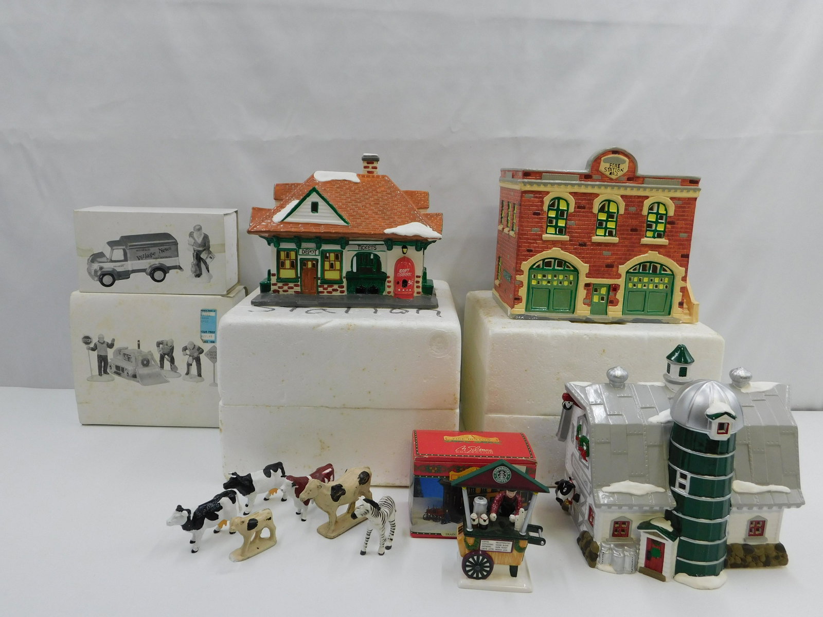 Group Lot of Mostly Dept 56 Items: Group Lot of Mostly Dept 56 Items including Snow Village Fire Station, Snow Village Station 1988, Village News Delivery Truck, Men at Work Accessory, and Dairy Barn. Comes with small lot of loose anim