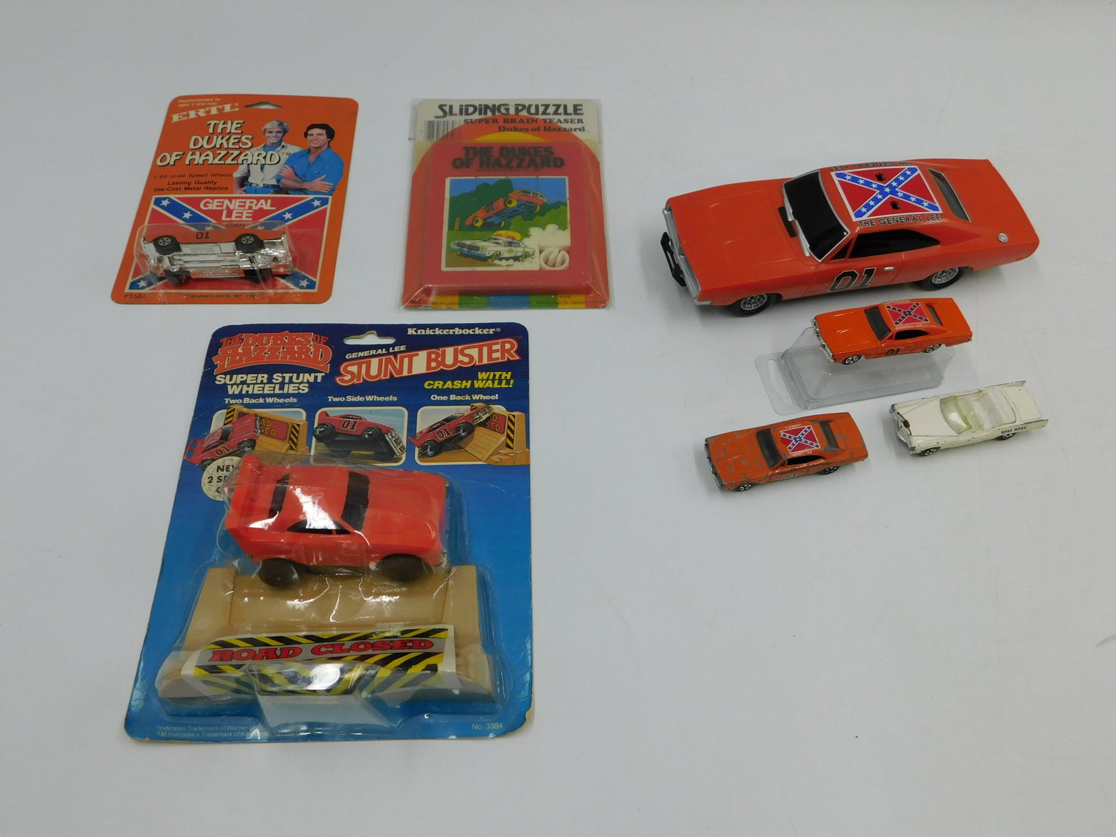 Lot of Dukes of Hazard Items: Lot of Dukes of Hazard Items including General Lee by Ertl - Mint on Card, Knickerbocker General Lee Stunt Buster - Mint on Card, Super Brain Teaser Slider Puzzle - Mint on Card, Loose General Lee Car