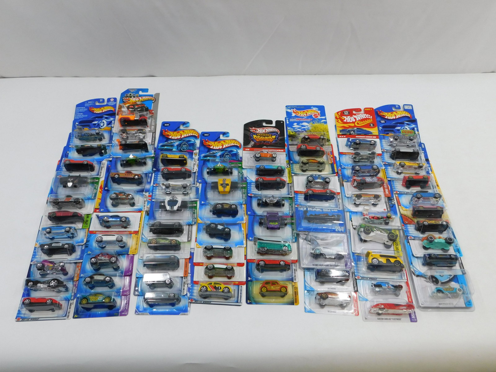 Lot of 75 Hot Wheels - All Mint on Card: Lot of 75 Hot Wheels - All Mint on Card. Some cars included in this lot are Enzo Ferrari, '10 Ford Shelby GT500 Super Snake, Custom Cadillac Fleetwood, VW Bug, Volkswagen Golf GTI, Porsche Carrera GT,
