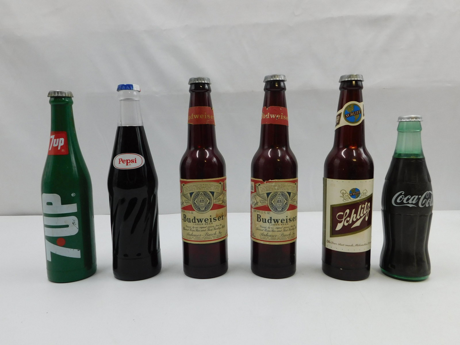 Lot of 6 Advertising Bottle Flashlights: Lot of 6 Advertising Bottle Flashlights. Includes Schlitz, Budweiser, Coca-Cola, Pepsi and 7-Up. All plastic. Three say Hong Kong. All appear to be in good condition with some scratching. Longest meas