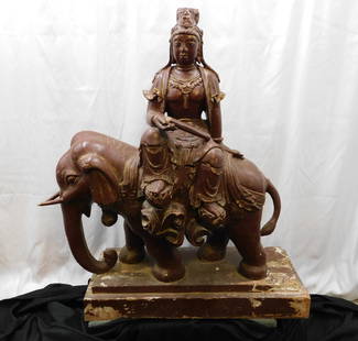 Lifesize Hand Carved Wooden Buddha Goddess Statue: Lifesize Hand Carved Wooden Buddha Goddess Statue. She is seated on an Elephant. Accented with jewels. Does have paint loss throughout. Has water damage on base. Stress marks and cracking throughout.