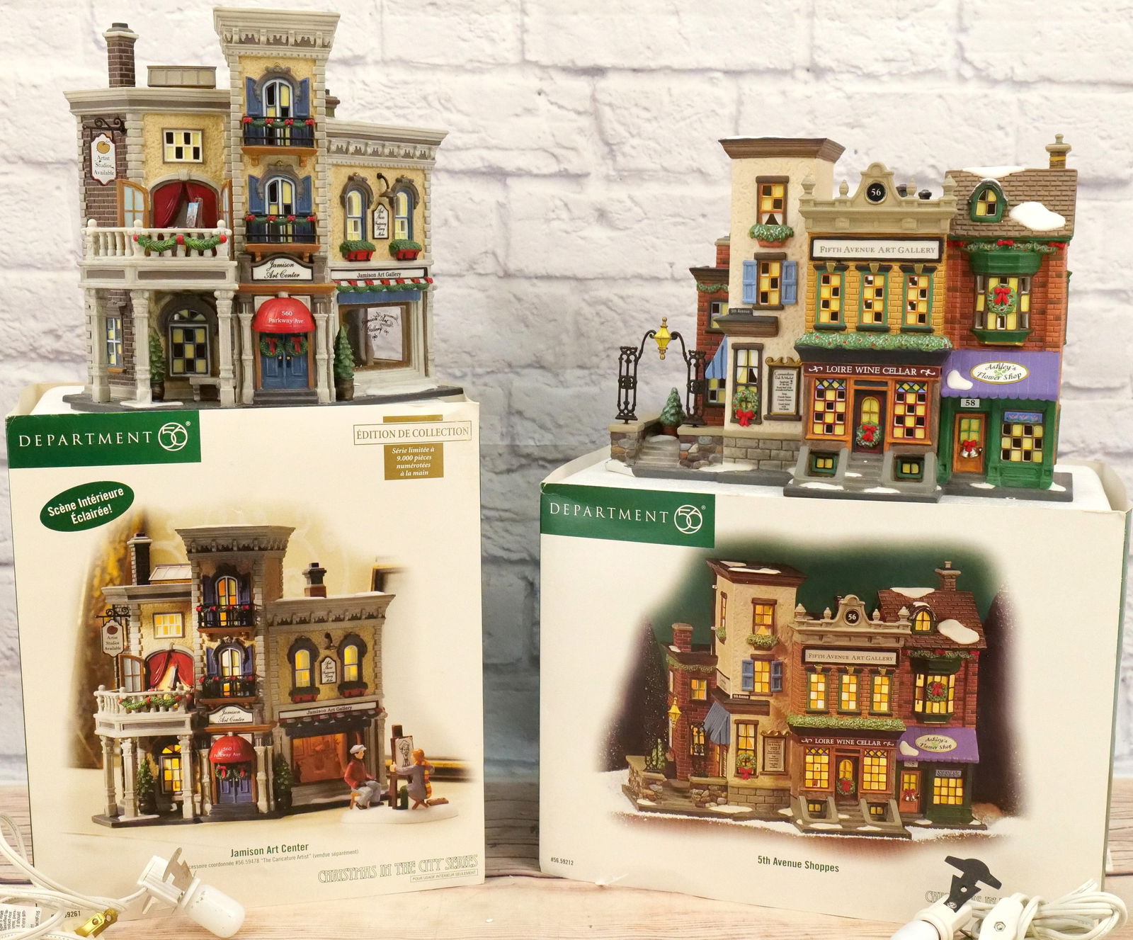 Lot of 2 Department 56 Christmas in the City Houses: Lot of 2 Department 56 Christmas in the City Houses including Jamison Arts Center - Appears to be in good condition and 5th Avenue Shoppers - Large broken chunk/chip on base. Both come with light cord