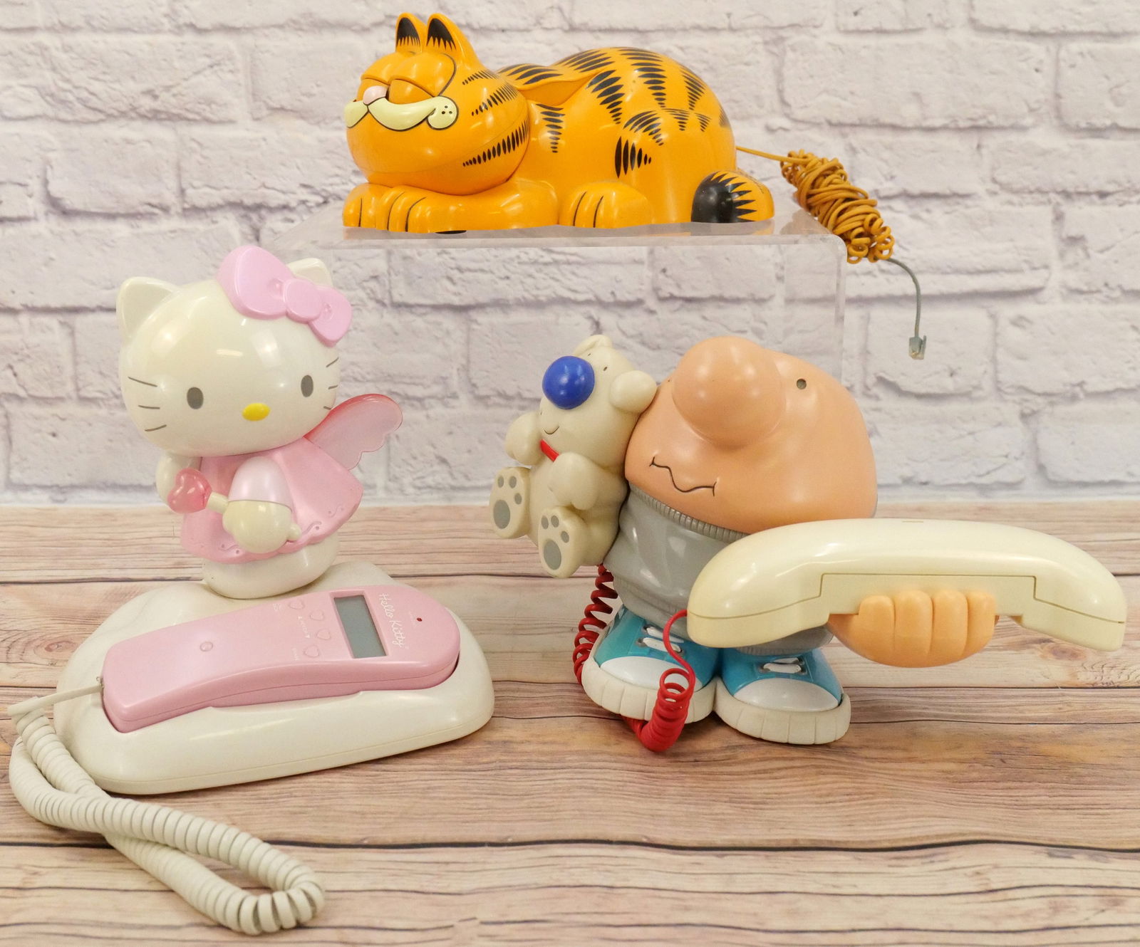 Lot of 3 Cartoon Related Novelty Telephones: Lot of 3 Cartoon Related Novelty Telephones. Including Hello Kitty, Garfield, and Ziggy. Garfield has some scratching present. Largest measures 10" tall x 9" wide. This Collection was displayed in the