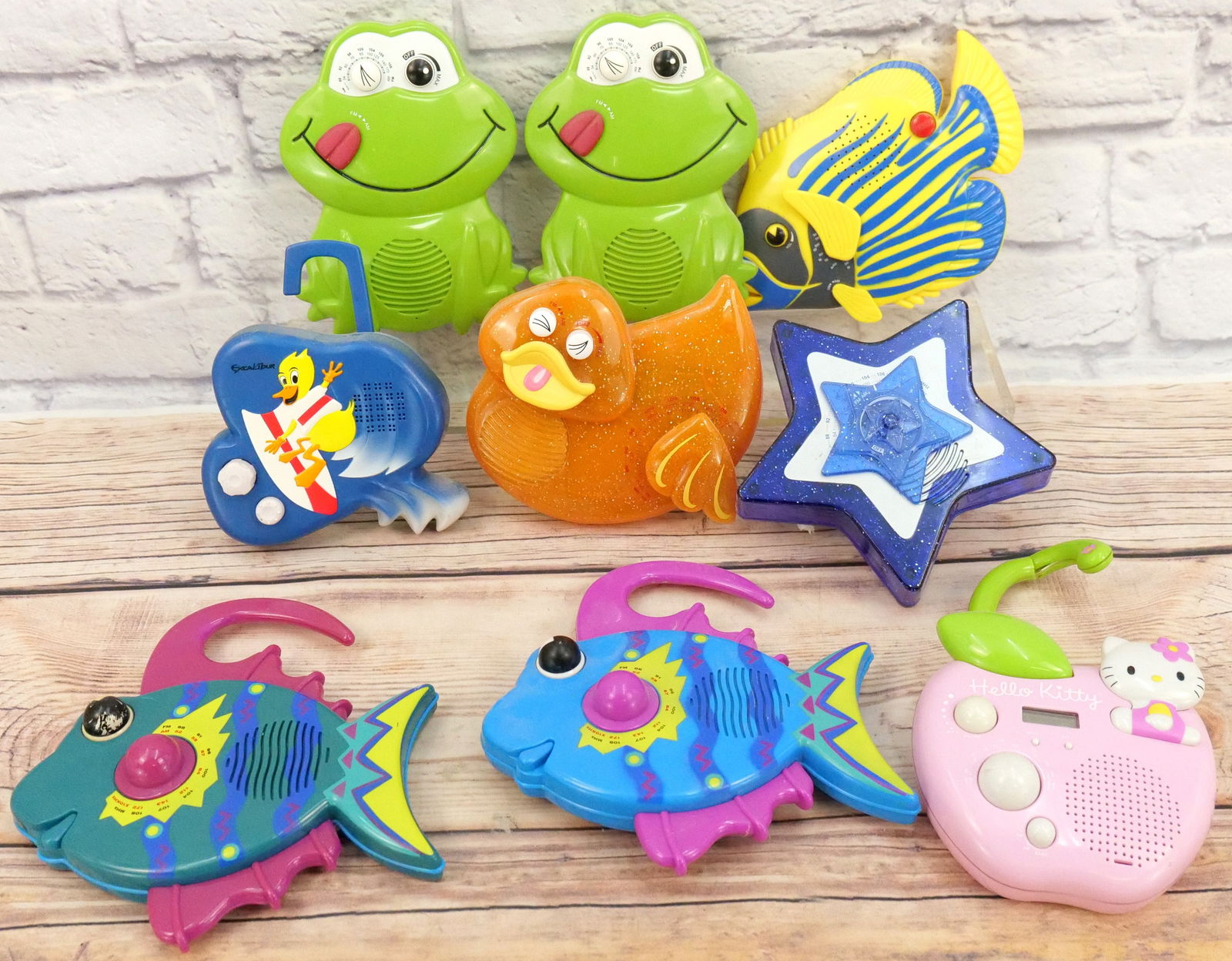 Lot of 9 Novelty Shower Radios: Lot of 9 Novelty Shower Radios including Hello Kitty - Crack on Handle, Fish, Frogs, Duck, Star, and More. All in Used Condition. This Collection was displayed in the house and all items are untested.