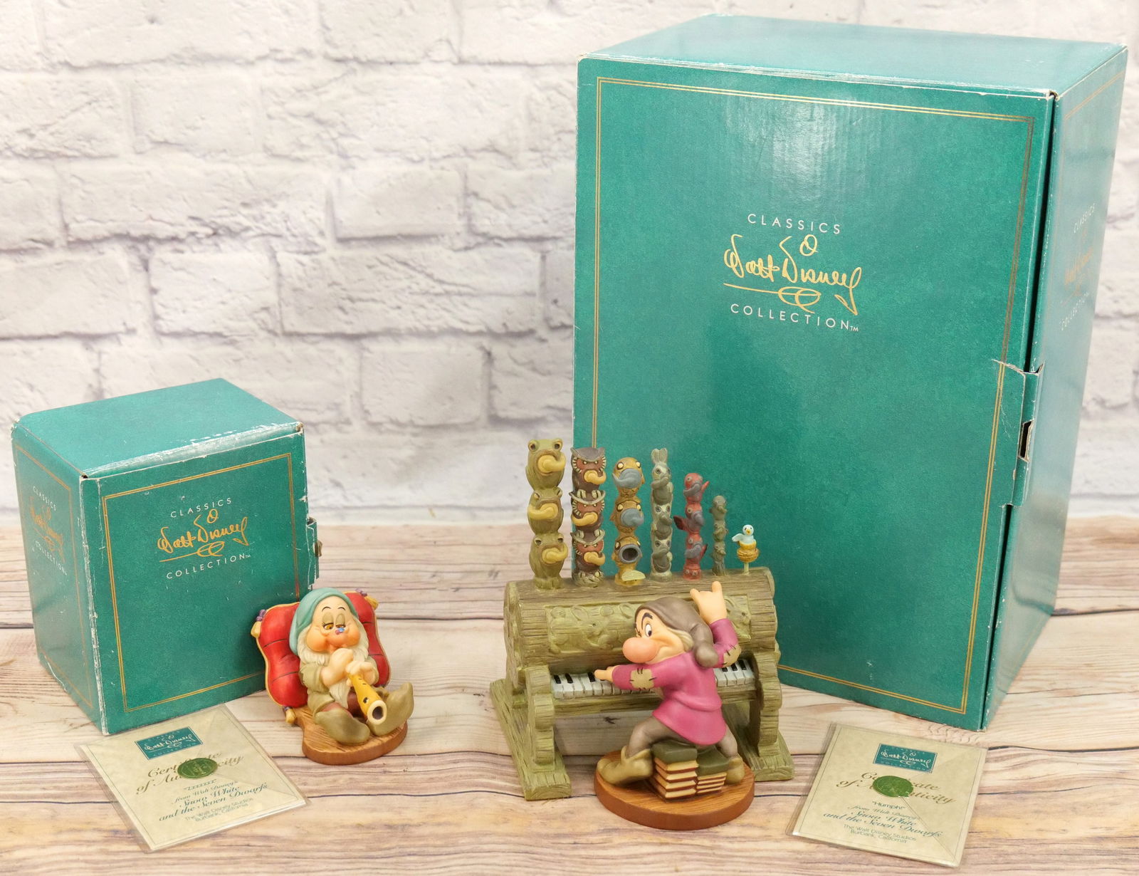 Lot of 2 WDCC Snow White Dwarf Figurines: Lot of 2 WDCC Snow White Porcelain Figurines including "Zzzzzzz" - Sleepy and "Humph" - Grumpy with Pipe Organ. The organ's bird in the nest is missing the outer wing. Largest measures approx. 7.5" ta